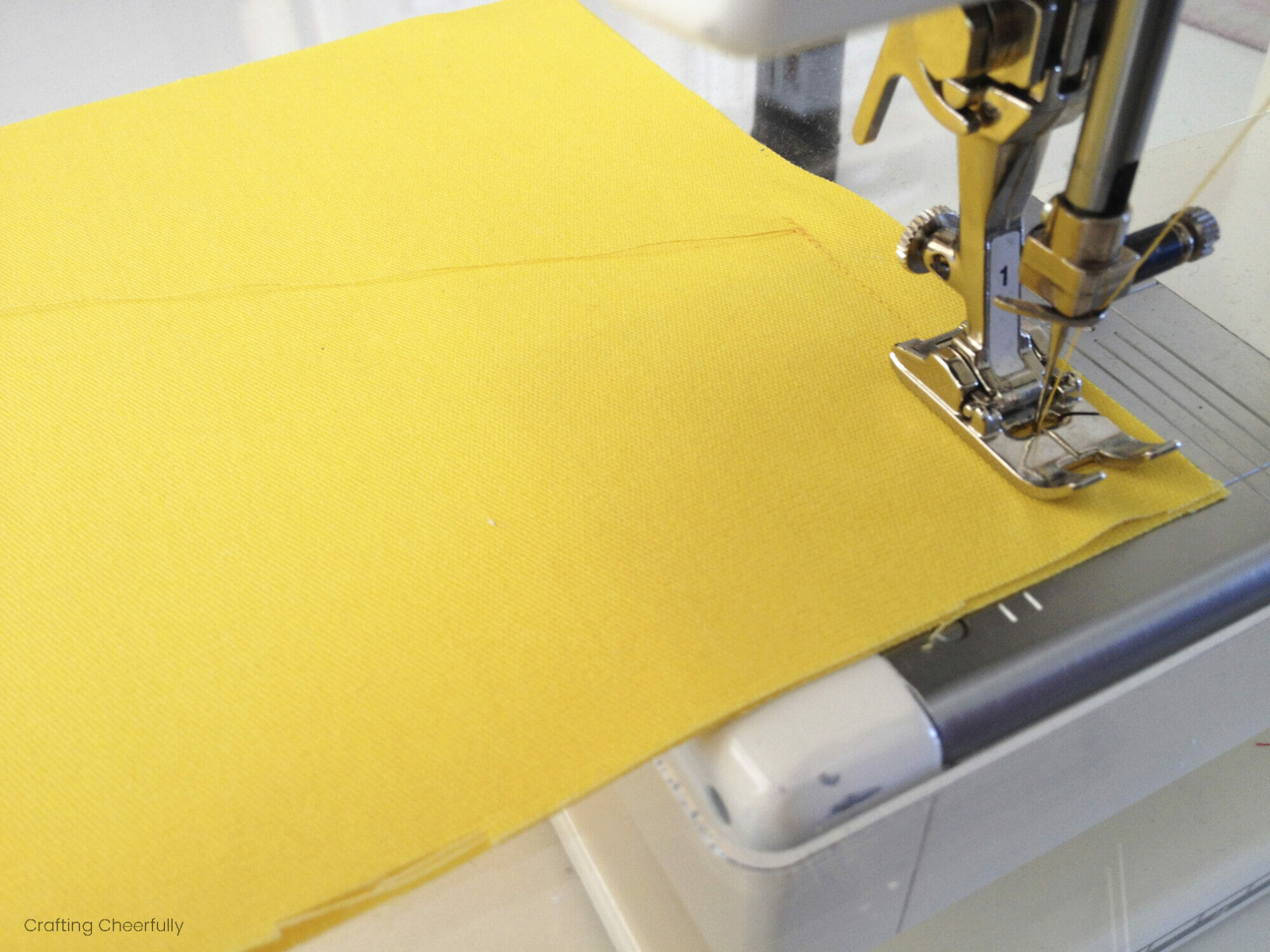 A sewing machine stitches along the edge of one of the bean bags.