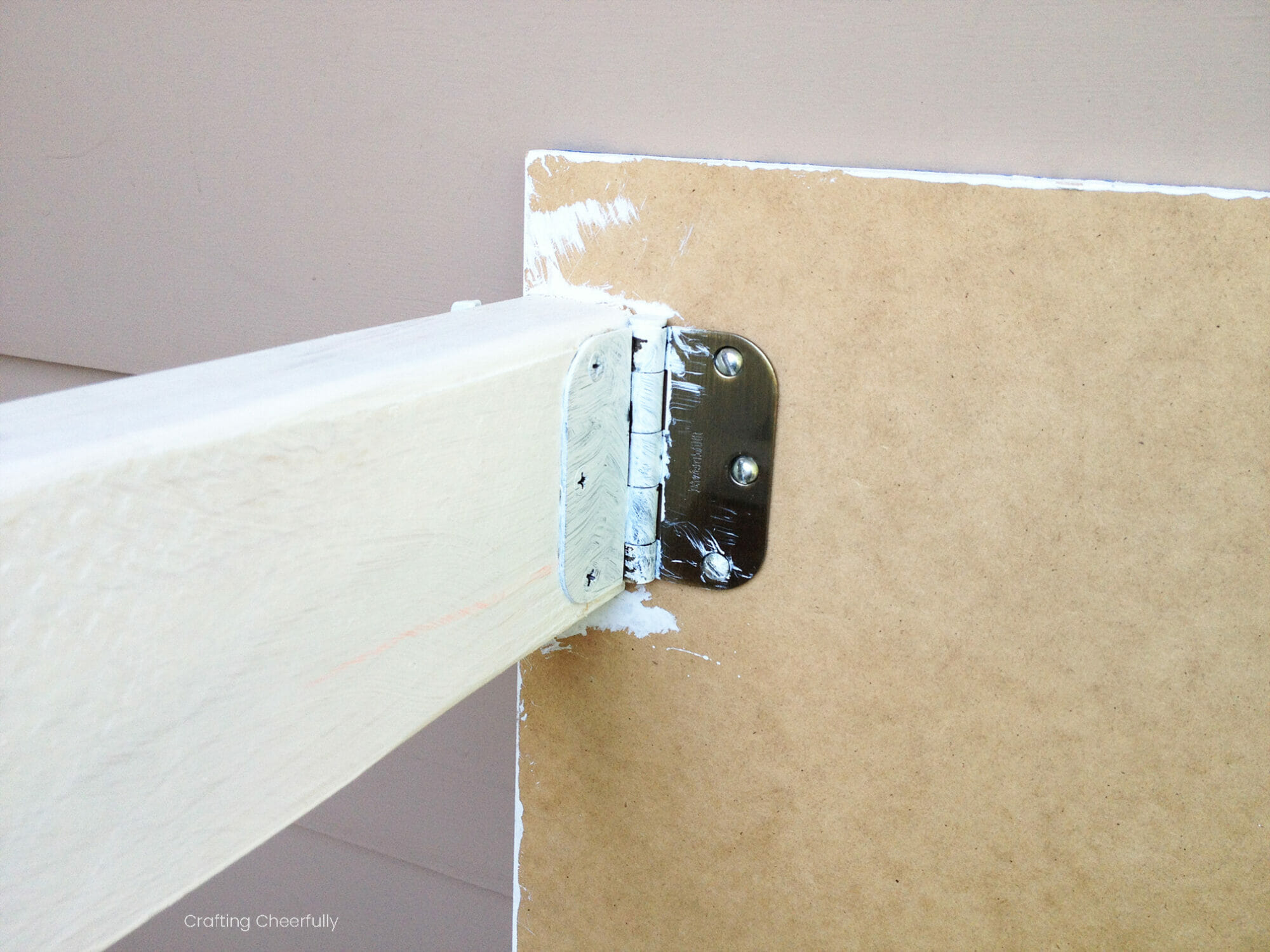 Hinges hold the wooden legs to the boards.
