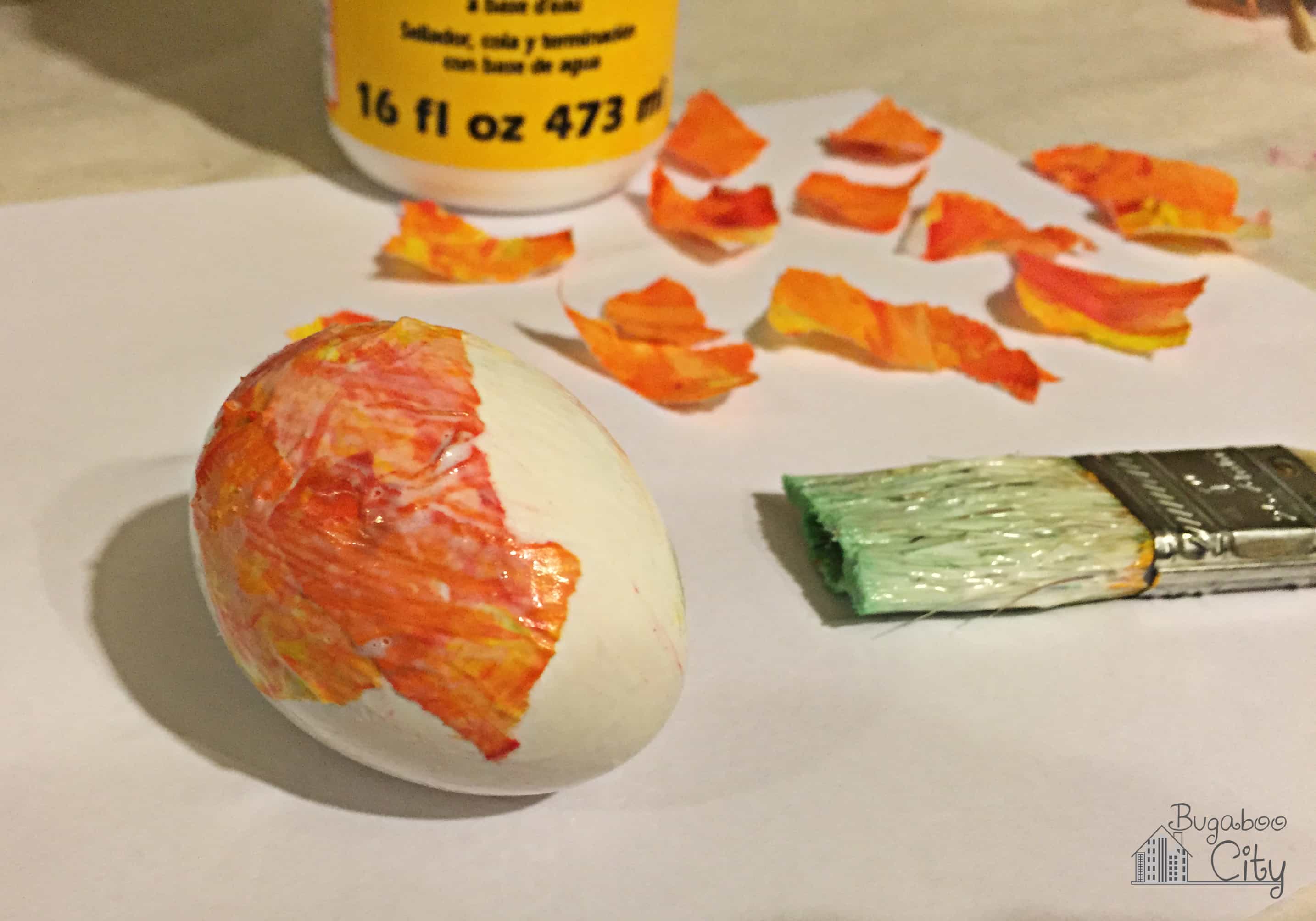 Egg is decoupaged with orange tissue paper.