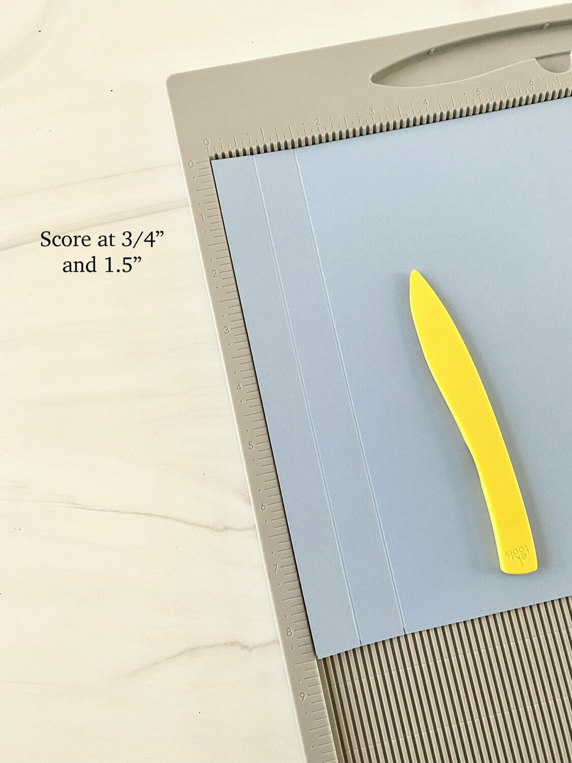Periwinkle paper scored at 3/5" and 1.5" marks.