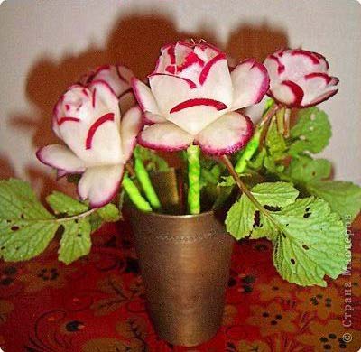Radishes cuts into the shape of flowers and put in a vase.