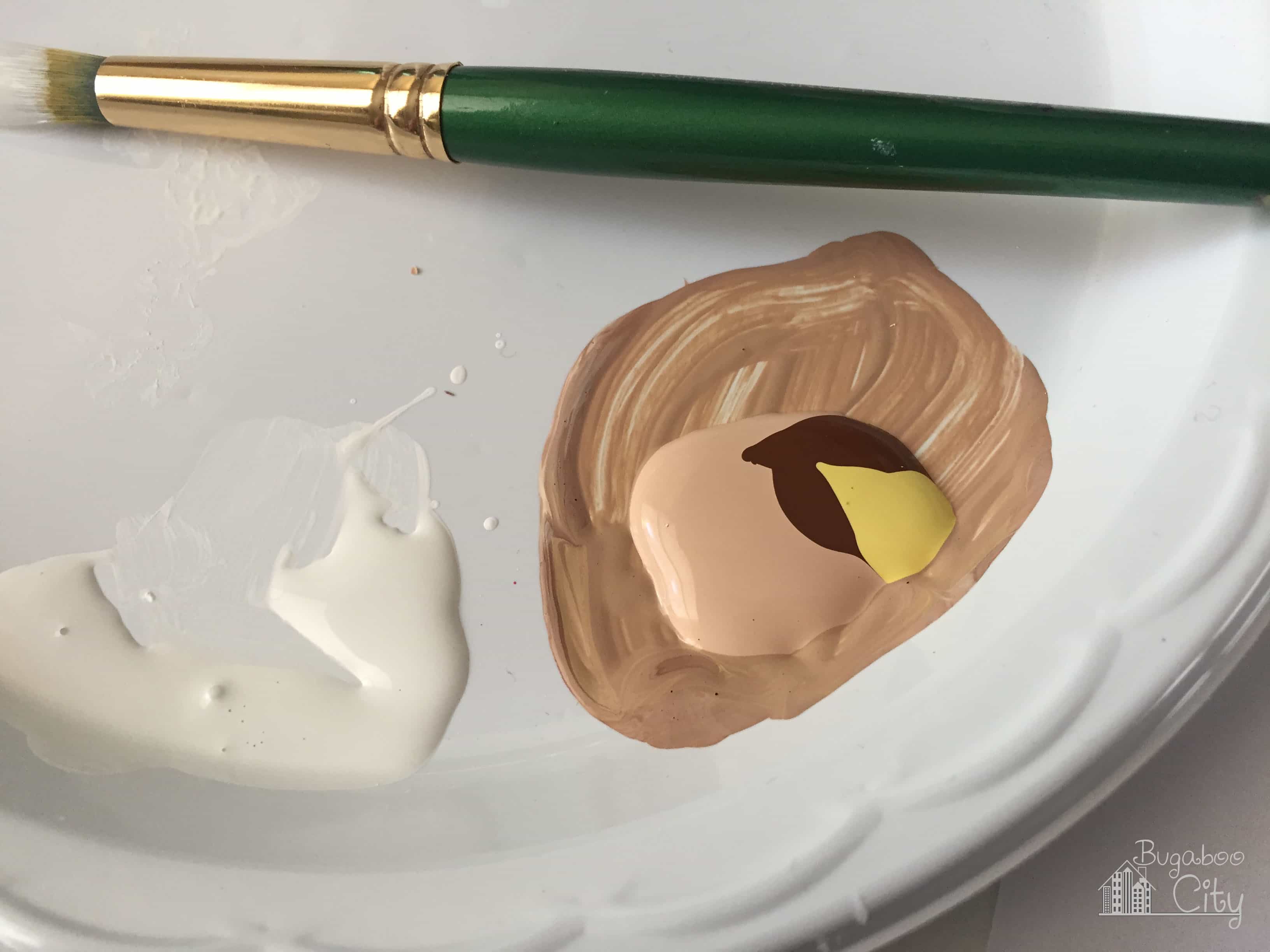 Paint being mixed on a paper plate.