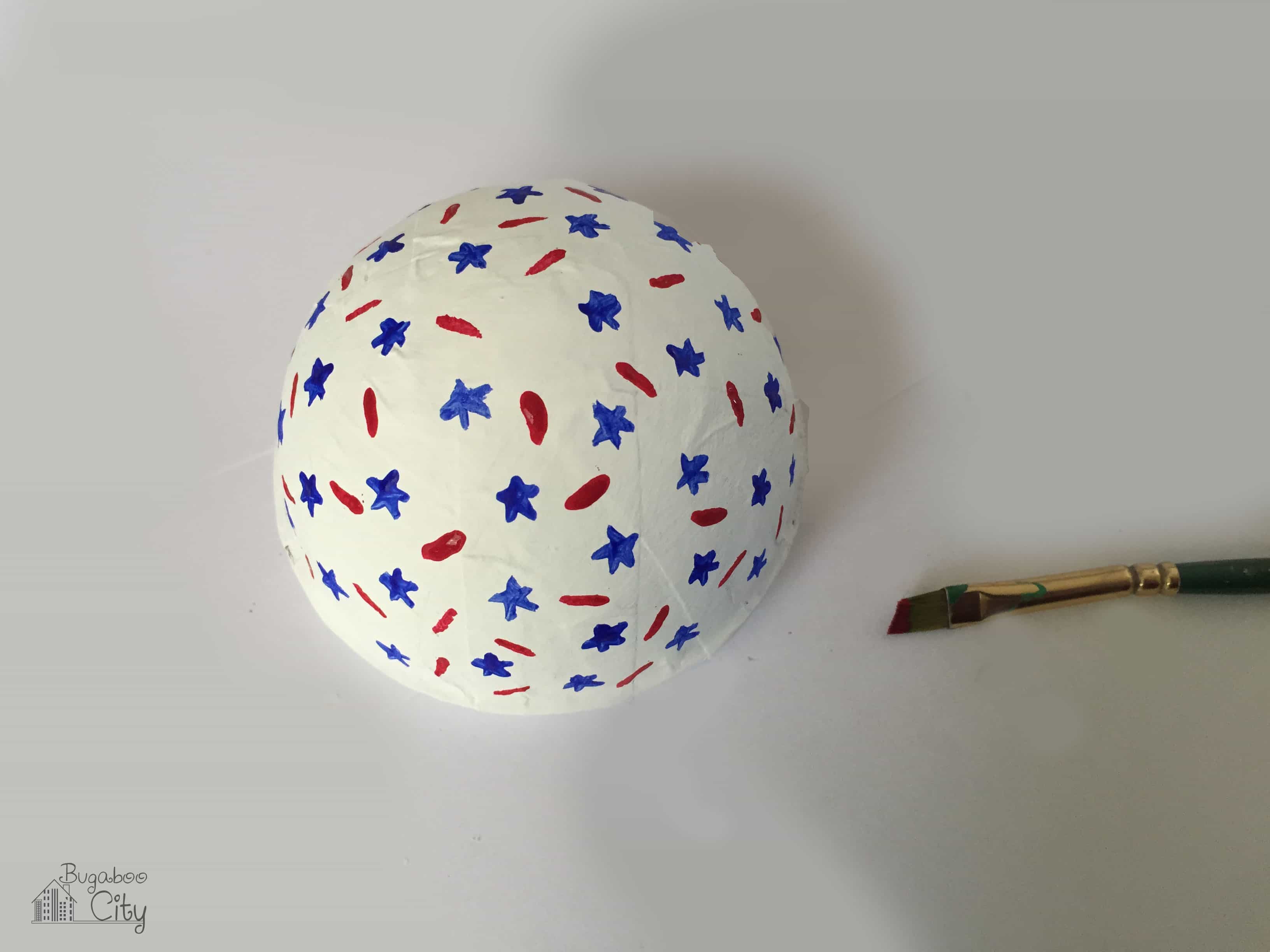 Red sprinkles are added with the blue star sprinkles with acrylic paint to the ice cream scoop lids.
