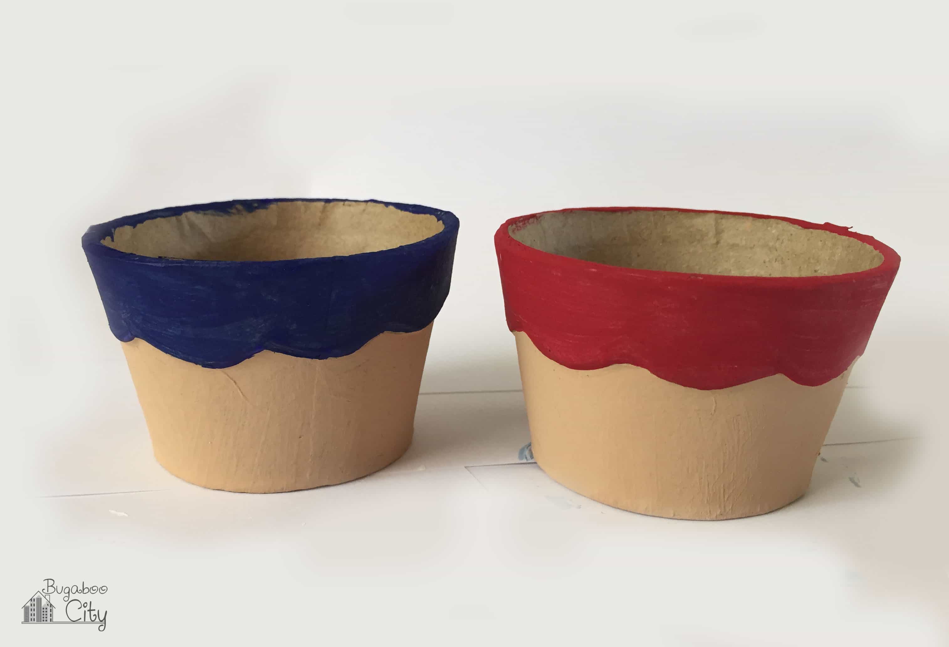 Cone boxes painted tan on the bottom and red and blue at the top.