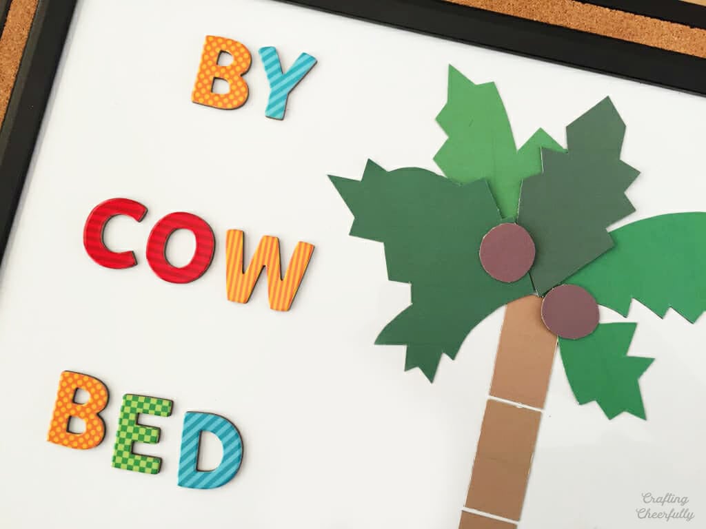 Dry erase board with magnetic letters that spell by, cow and bed.