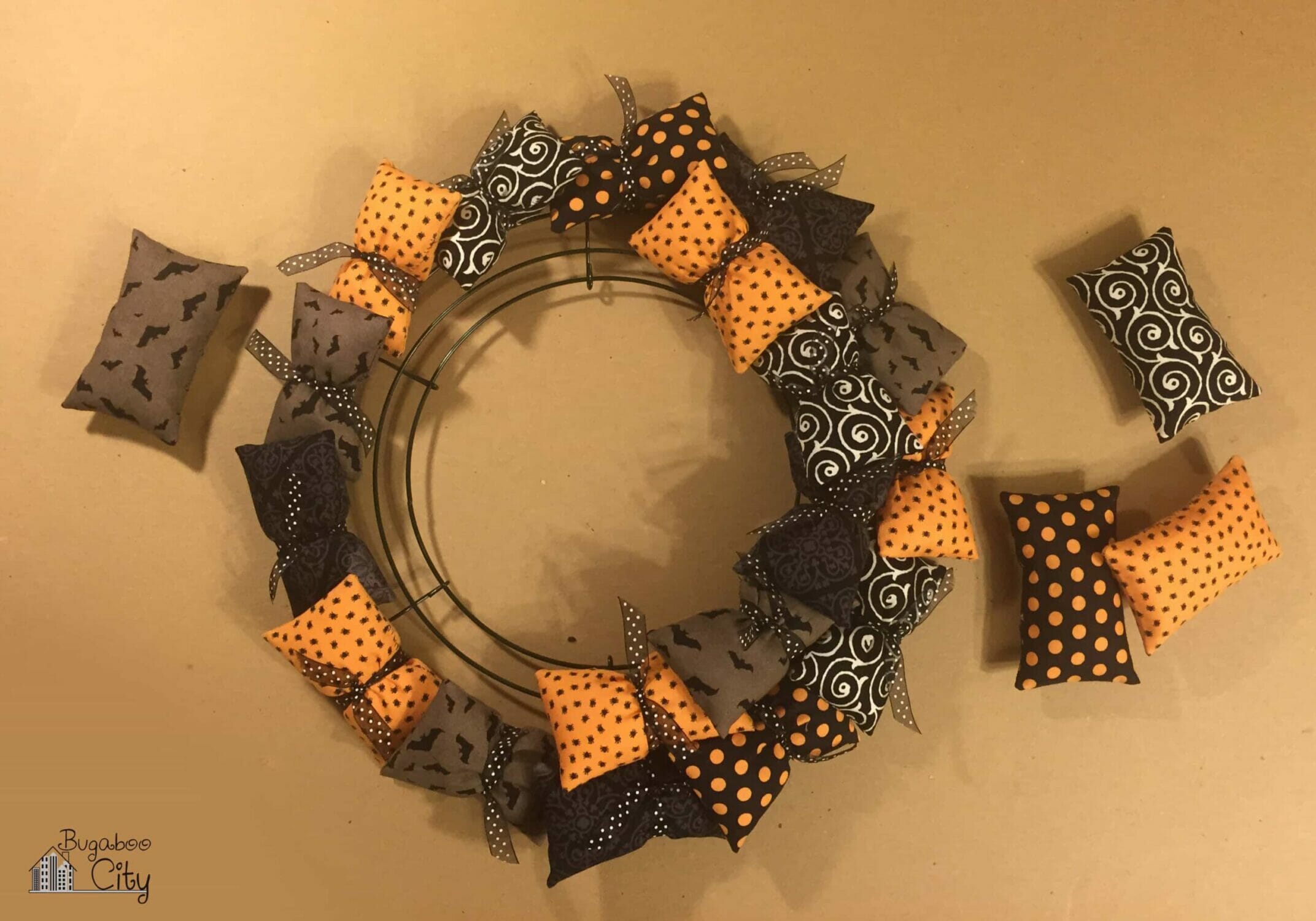 Pillows are attached to the wire wreath frame using strips of ribbon.
