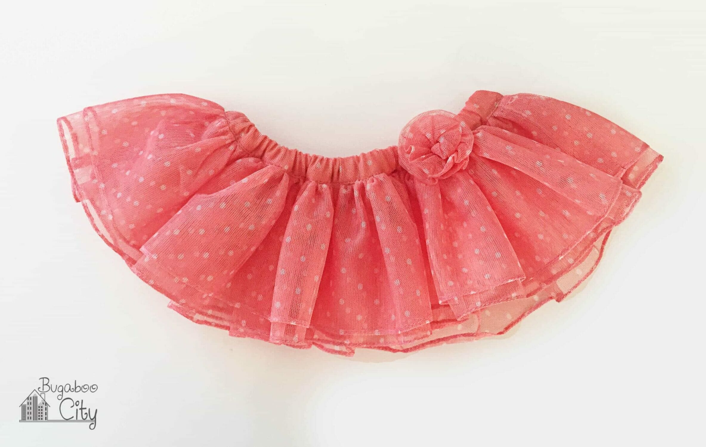 A pink tutu with pink tulle flower on the waistband.