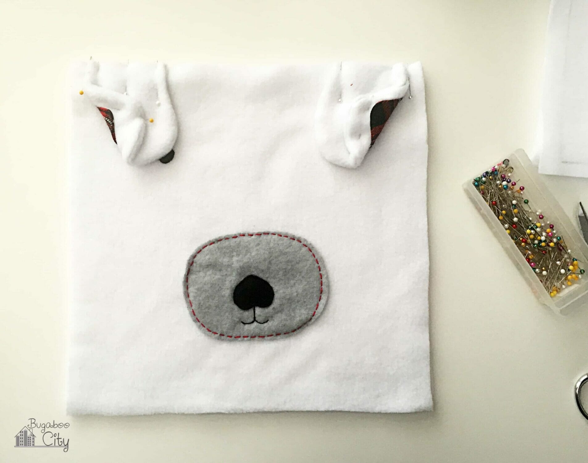 Polar bear ears are pinned away from the sides of the pillow.