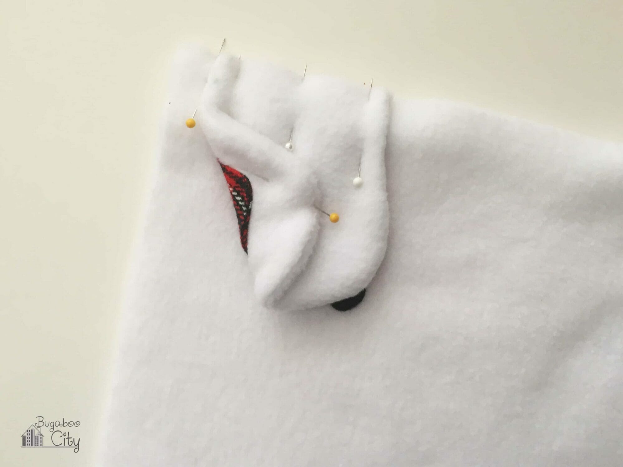 Polar bear ear is pinned away from the side of the fleece pillow.