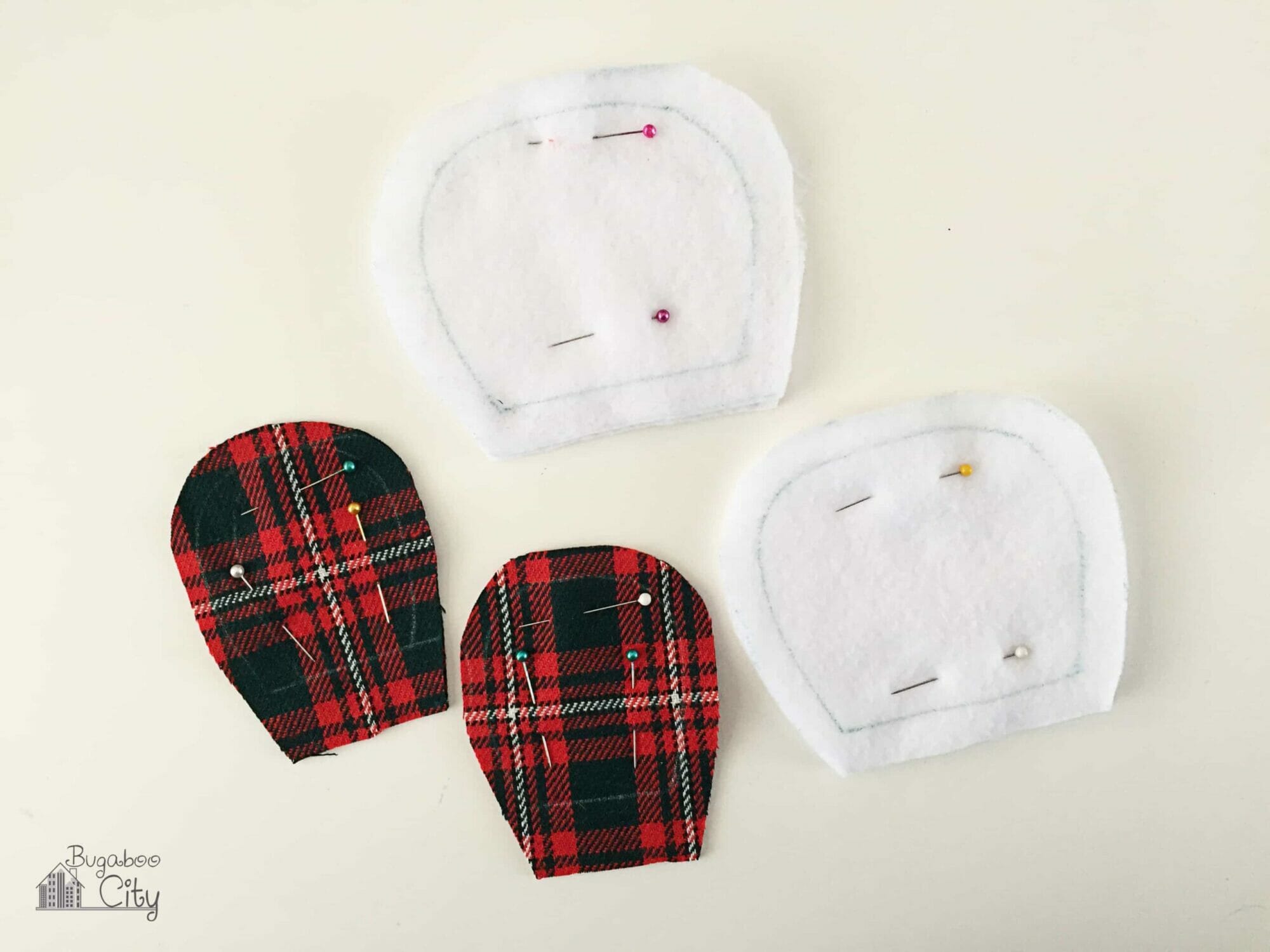 White fleece ears and red plaid inner ears are pinned.