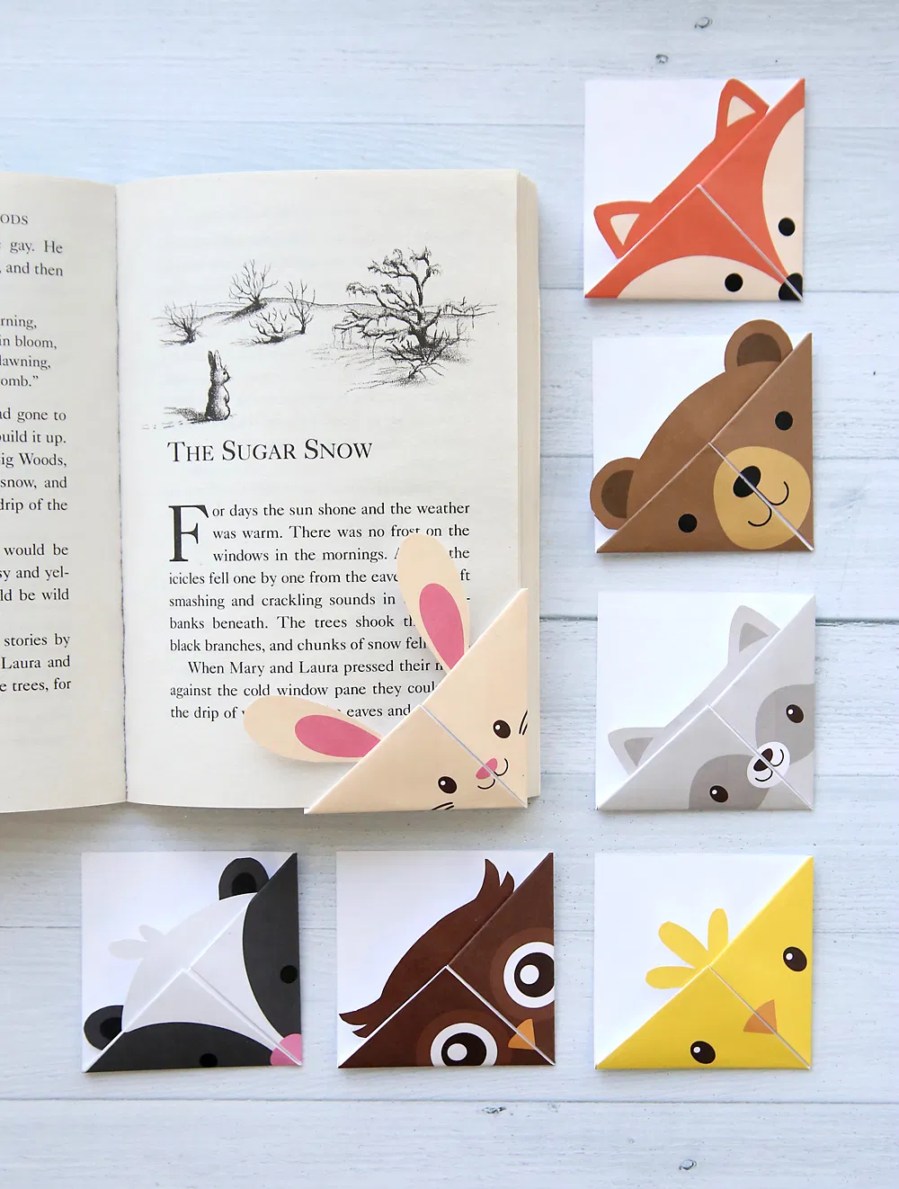 Woodland animal corner bookmarks surround a book.