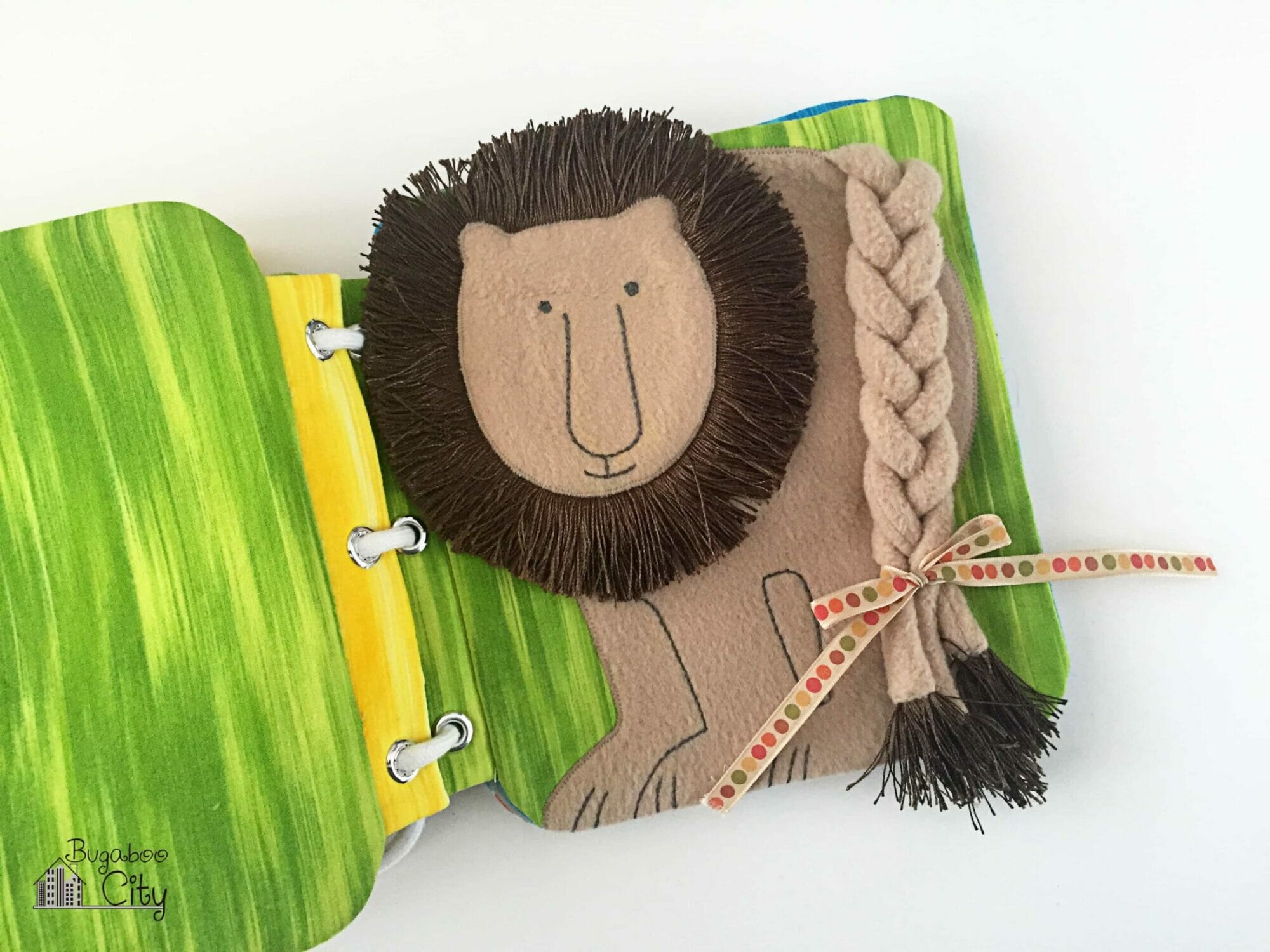 Fabric book page with fleece lion with a fringe main and a large braided tail.