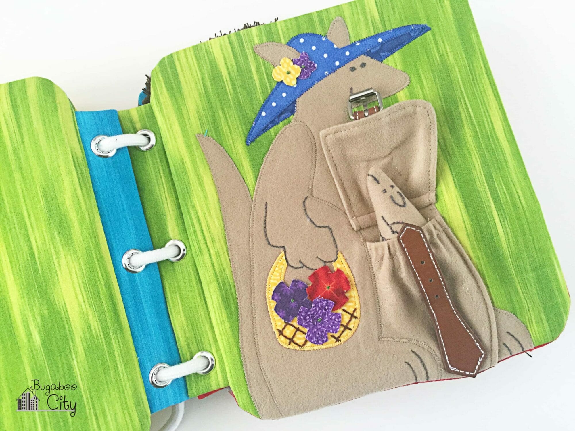 The fabric pouch on the kangaroo is unbuckled revealing a small fabric joey.
