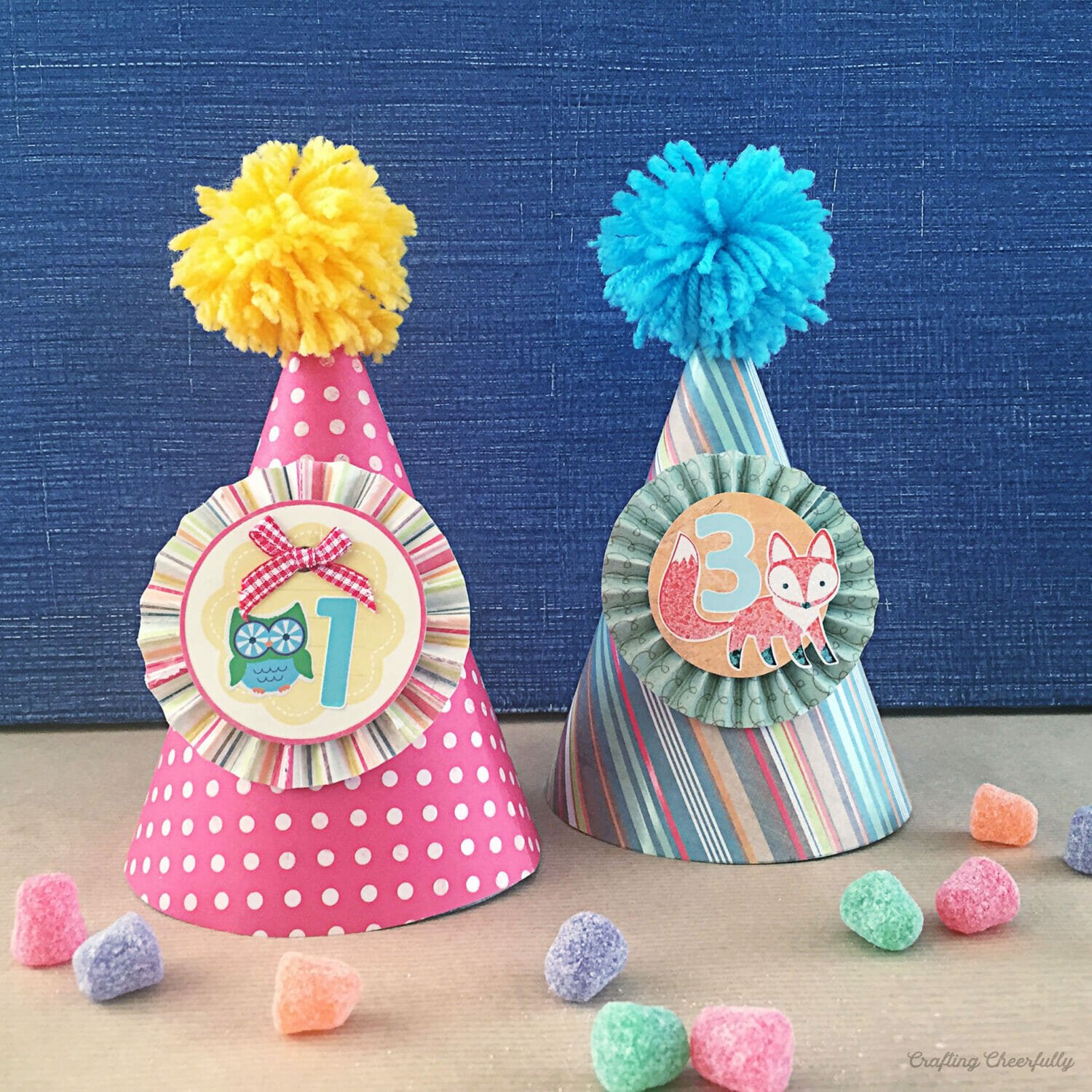 Two paper party hats; one has a number one on it, the other a number 3 on it.
