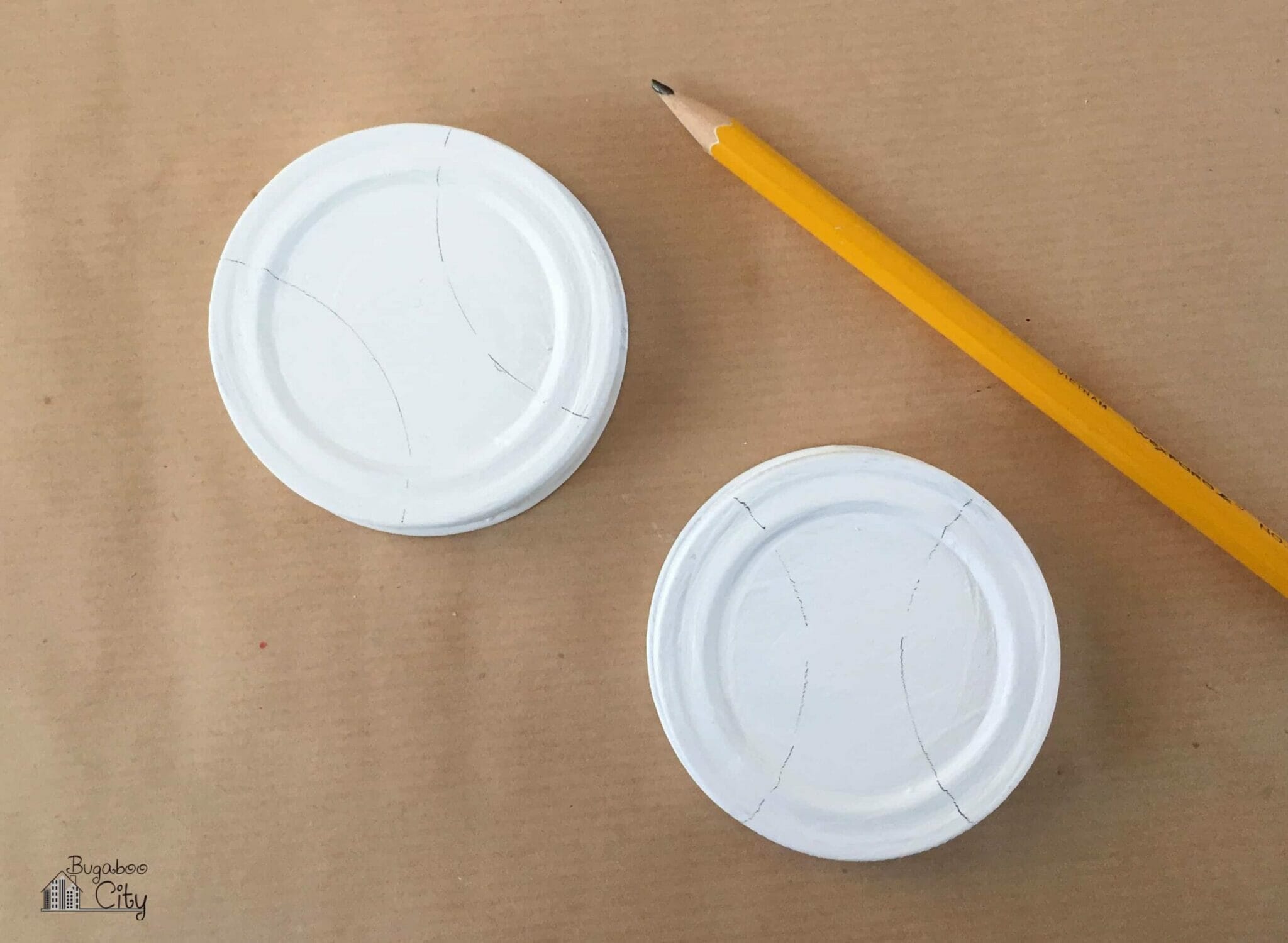 Pencil lines are drawn on the white mason jar lids to look like baseball stitching.