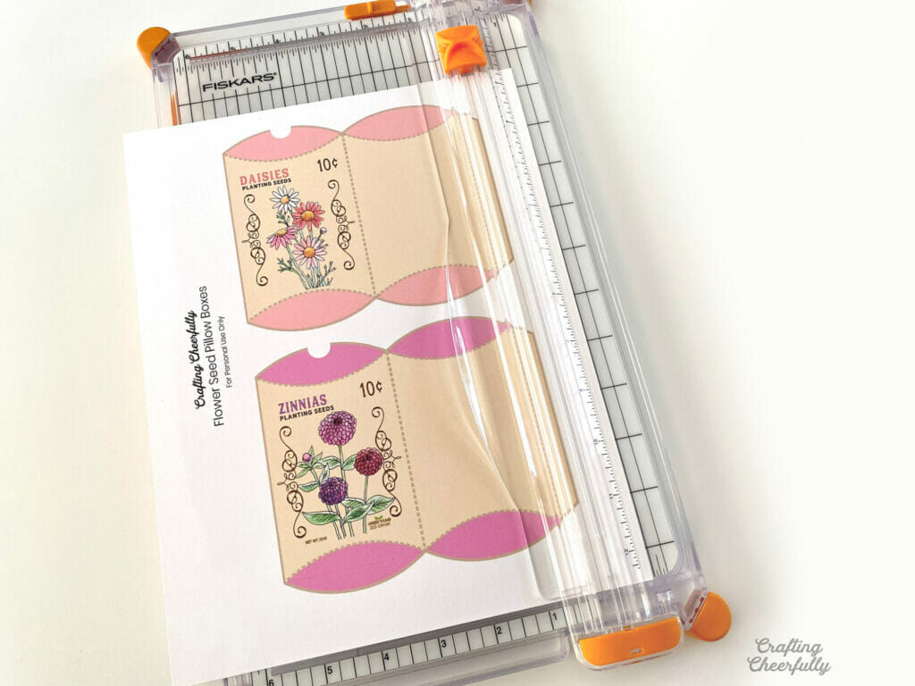 Paper trimmer cutting out treat boxes on a white table.