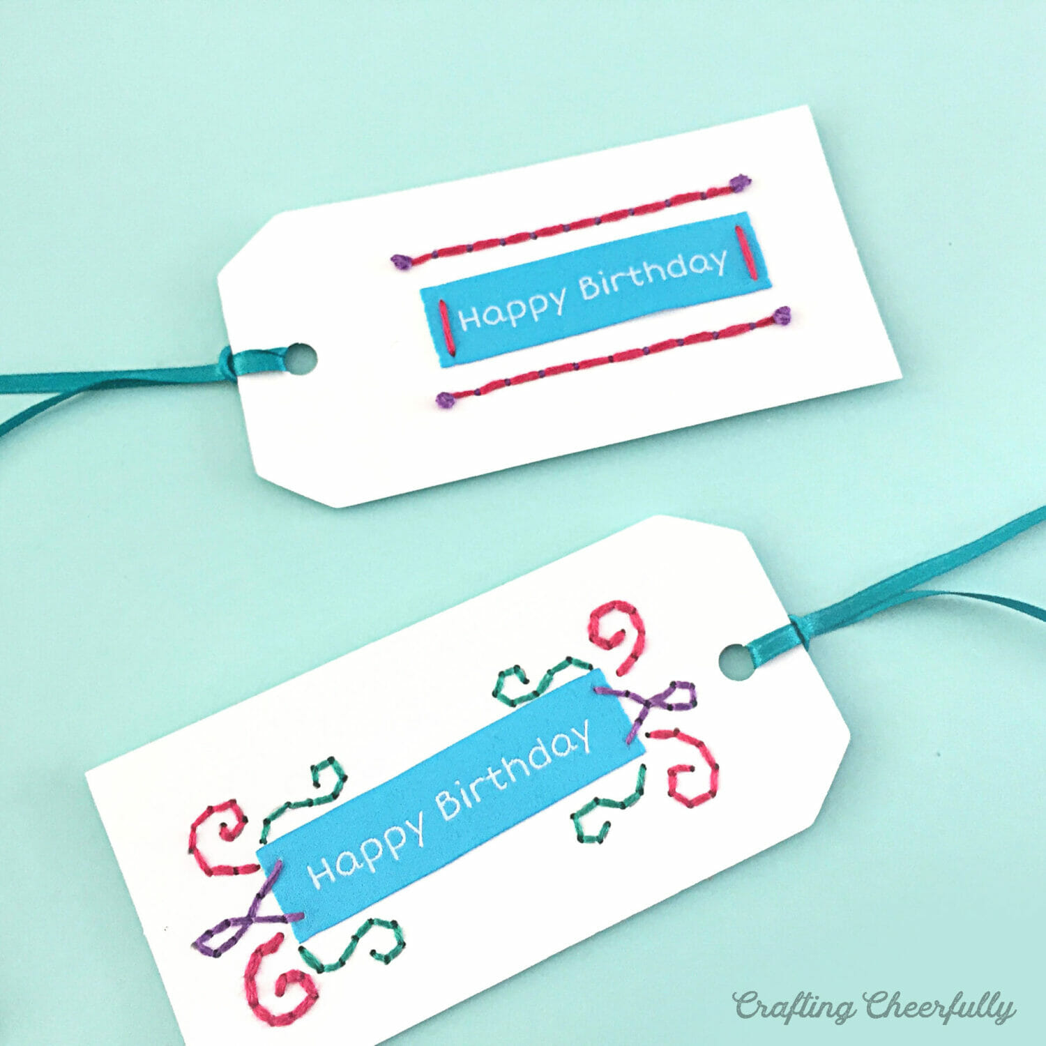 Paper gifts tags with embroidered designs and fabric tags that read Happy Birthday.