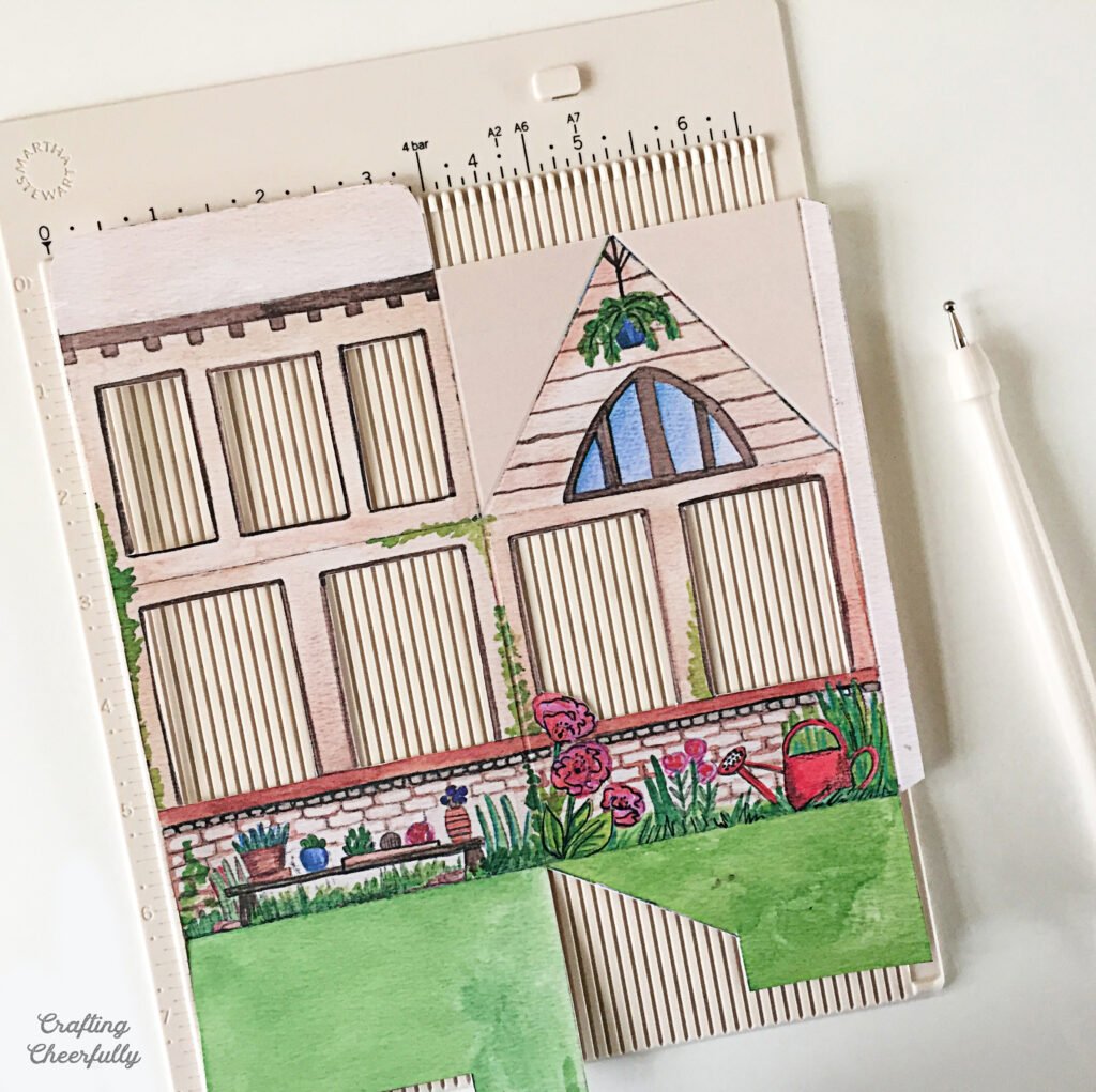 Printed paper greenhouse gift box on a scoring board.