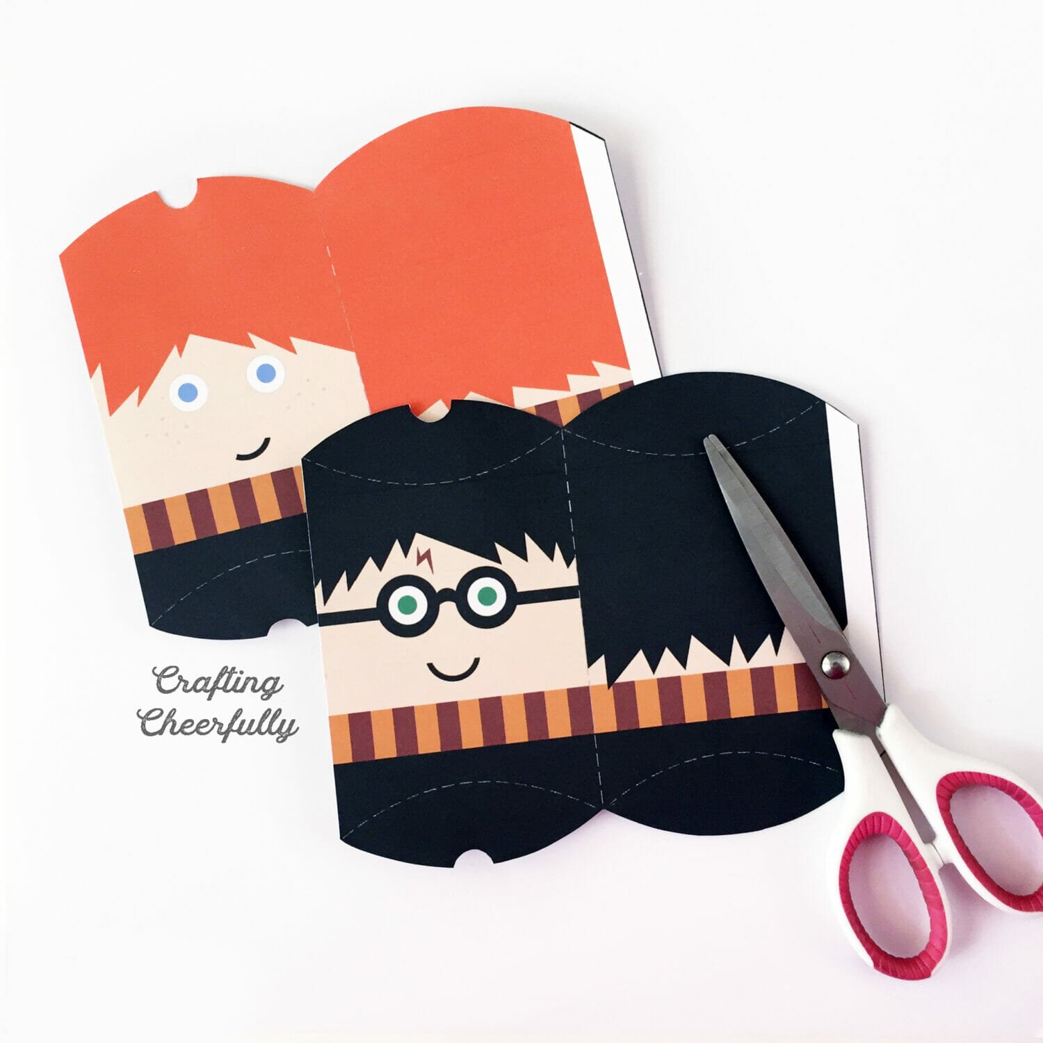 Harry and Ron printable favor boxes cut out and laying next to a scissors.