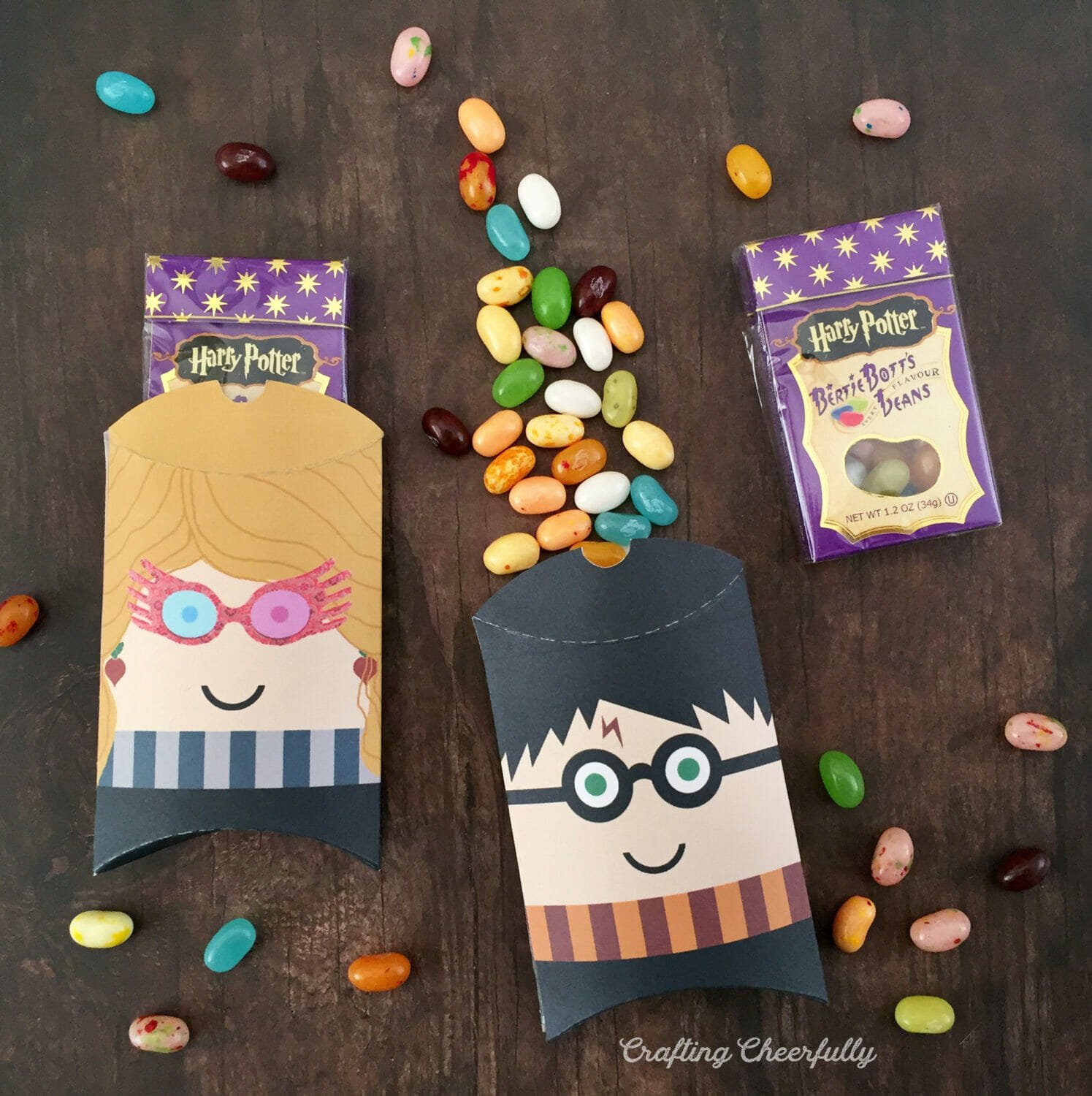 Harry Potter and Luna Lovegood paper treat boxes lay on a table with jellybeans spilling out.