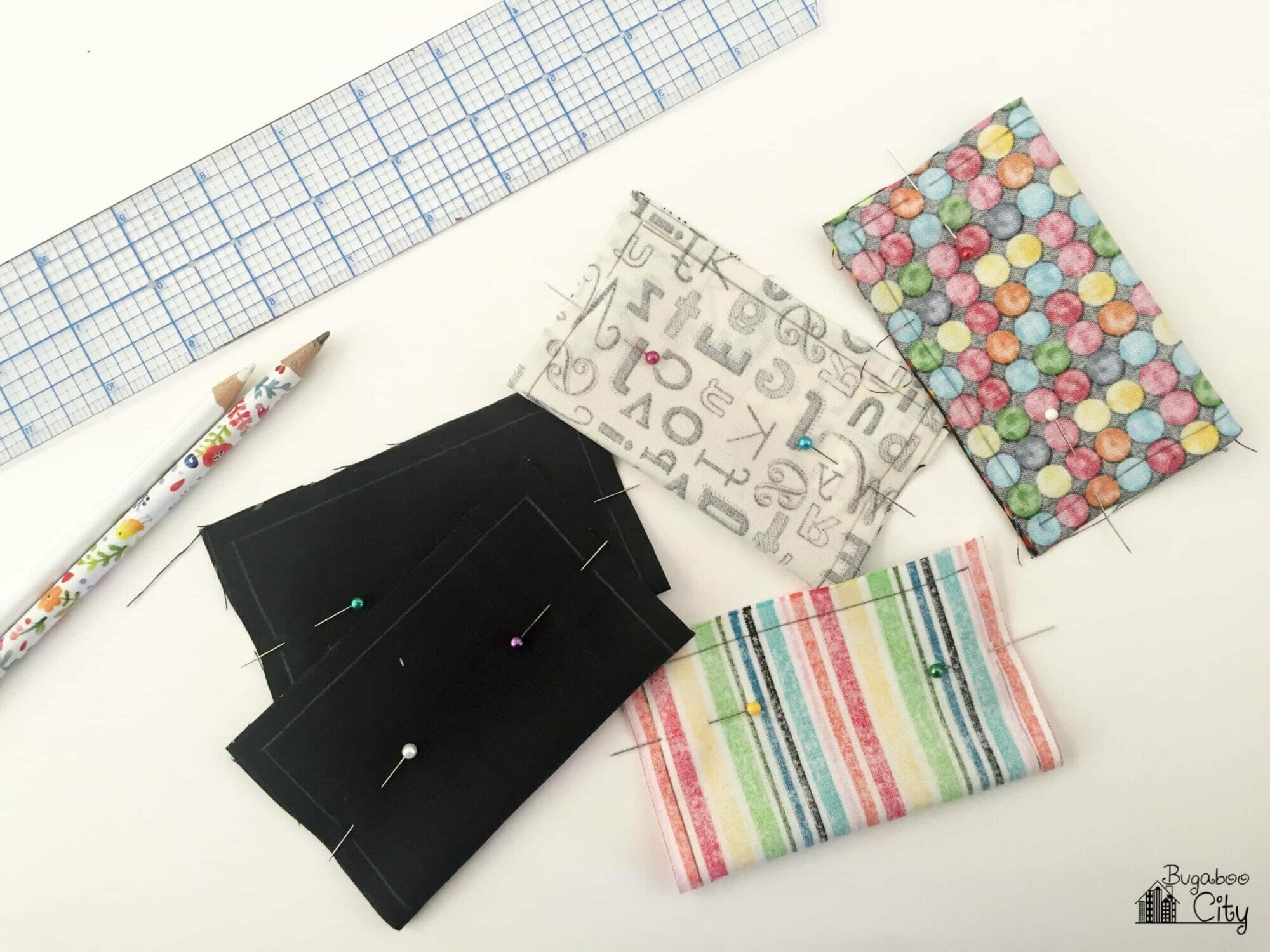 Five pieces of fabric are folded and pinned ready to be sewn.