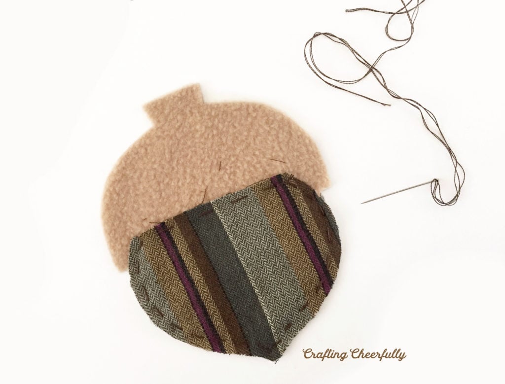 The bottom of the acorn is stitched using a small running stitch and brown embroidery floss.
