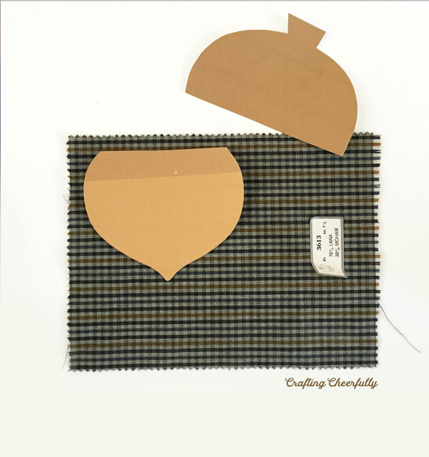 The bottom of the acorn template is laid on a piece of plaid shirting.