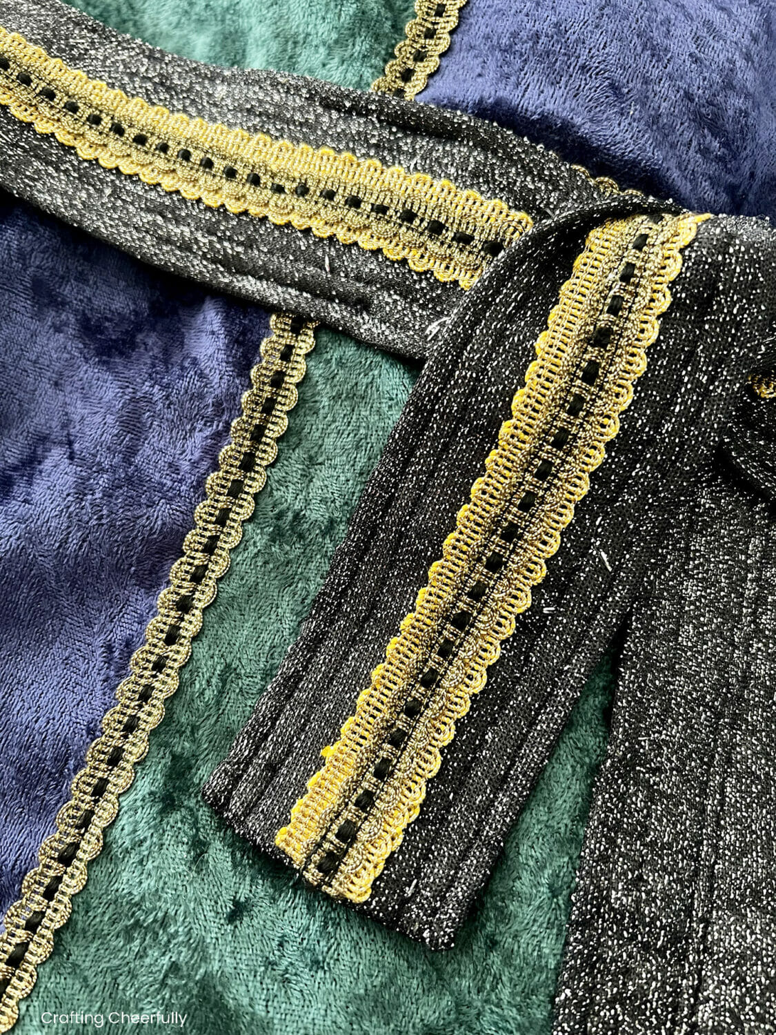 Belt on the tabard is made from black glittery fabric and gold trim.