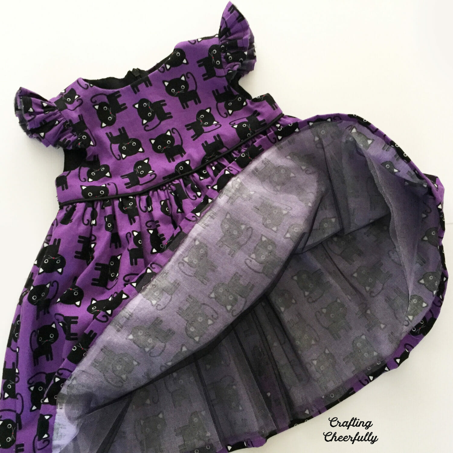 The skirt of the black cat dress is lifted up to show all of the layers of tulle underneath.