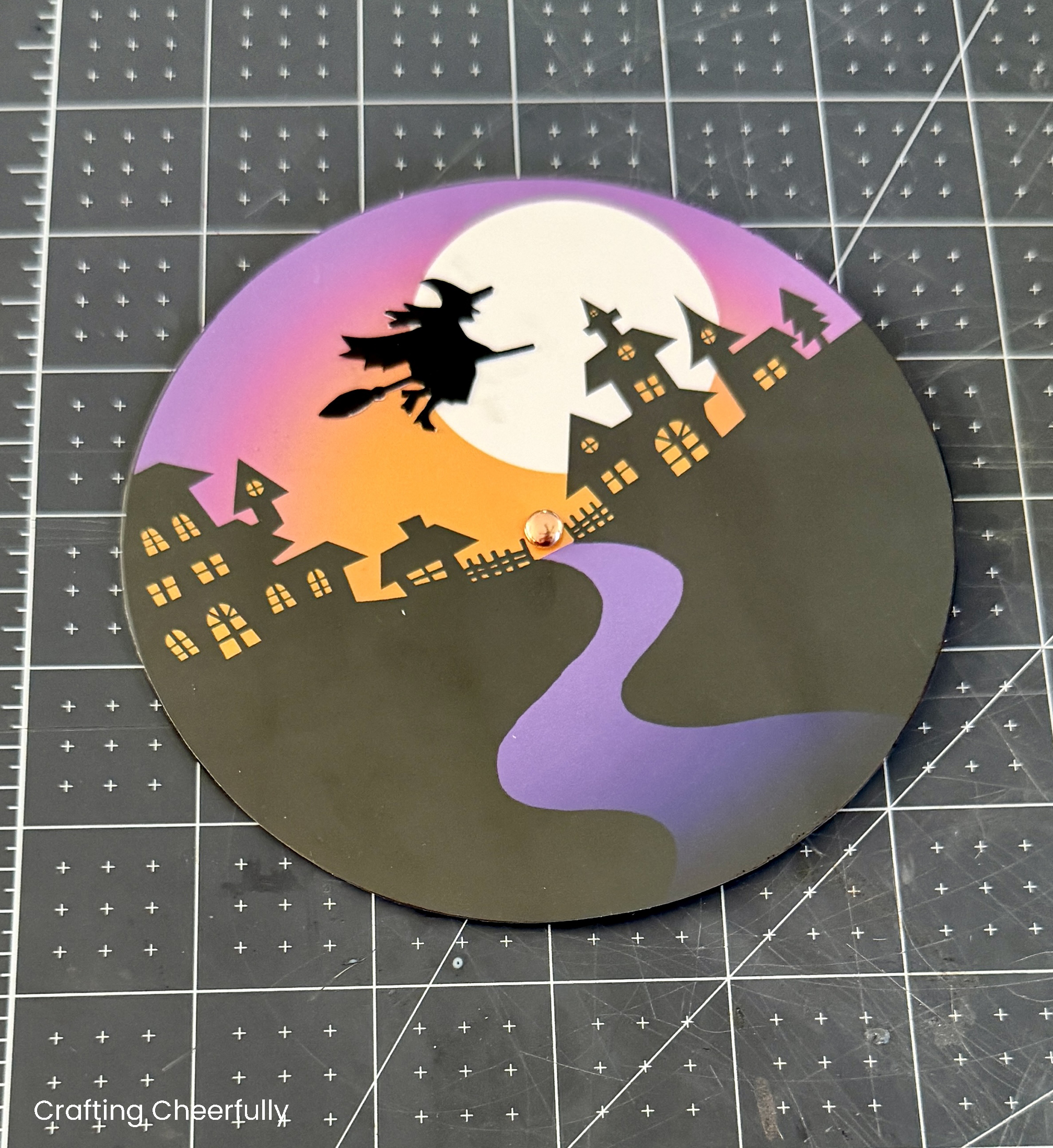 The witch is added to the top of the snow globe to complete the Halloween scene.