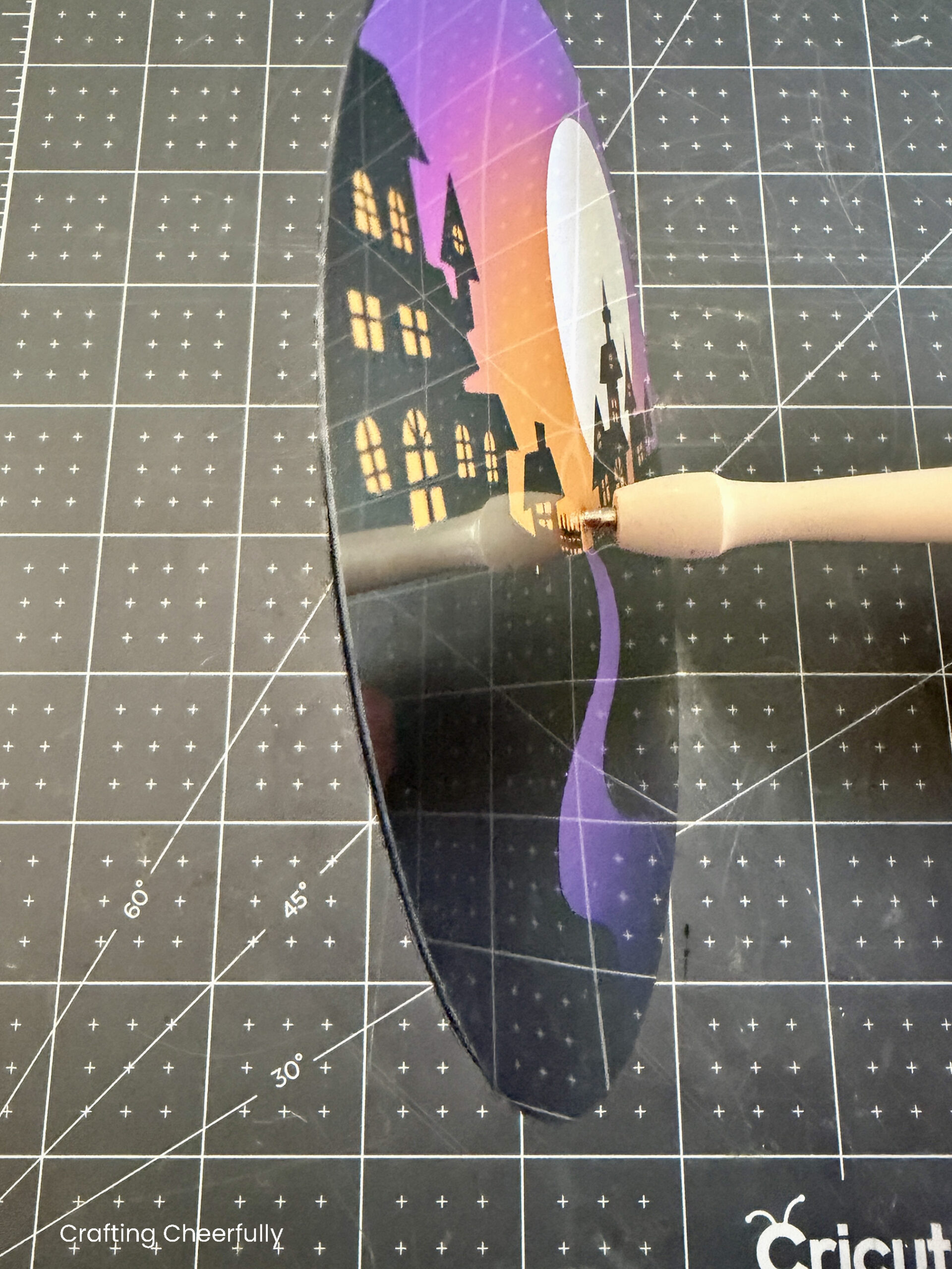 A stylus is used to punch a hole into the center of the snow globe wheel.