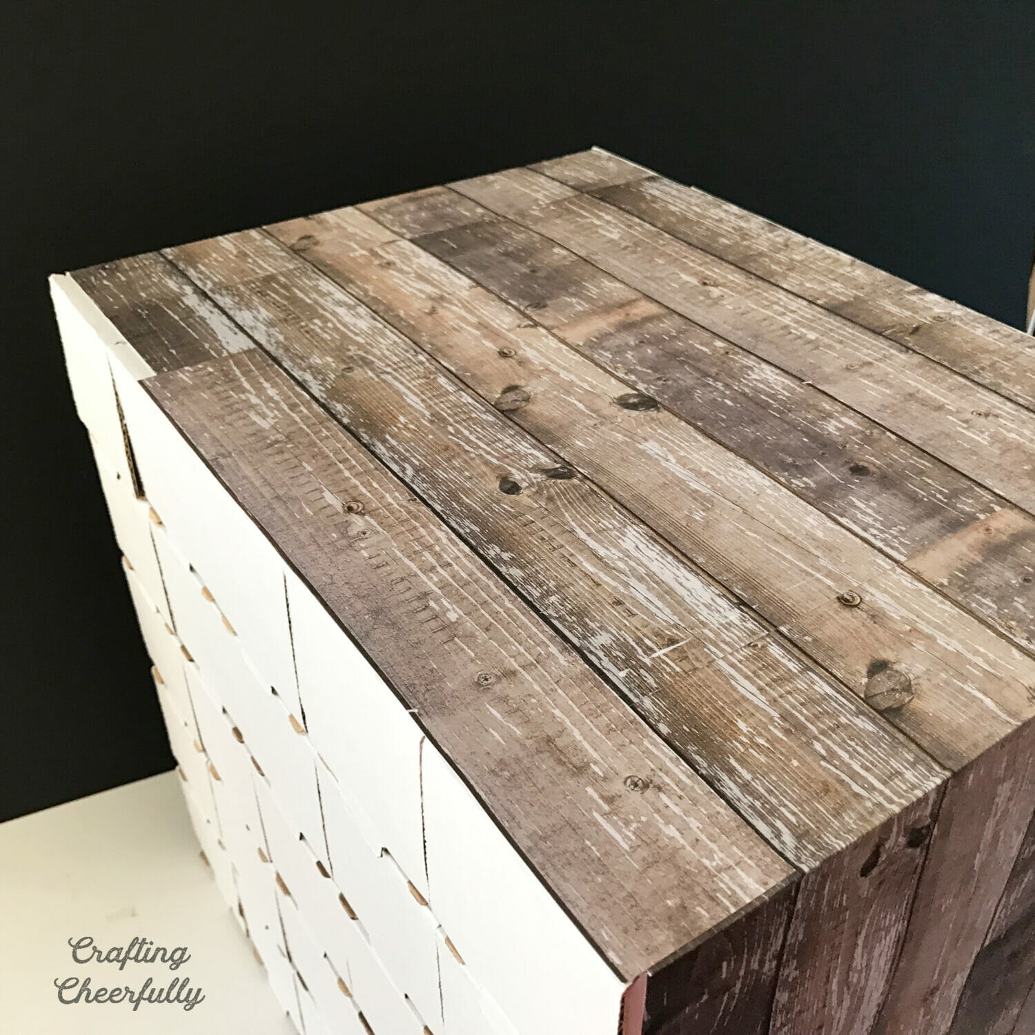 The top of the advent calendar is completely covered with wood grain paper.