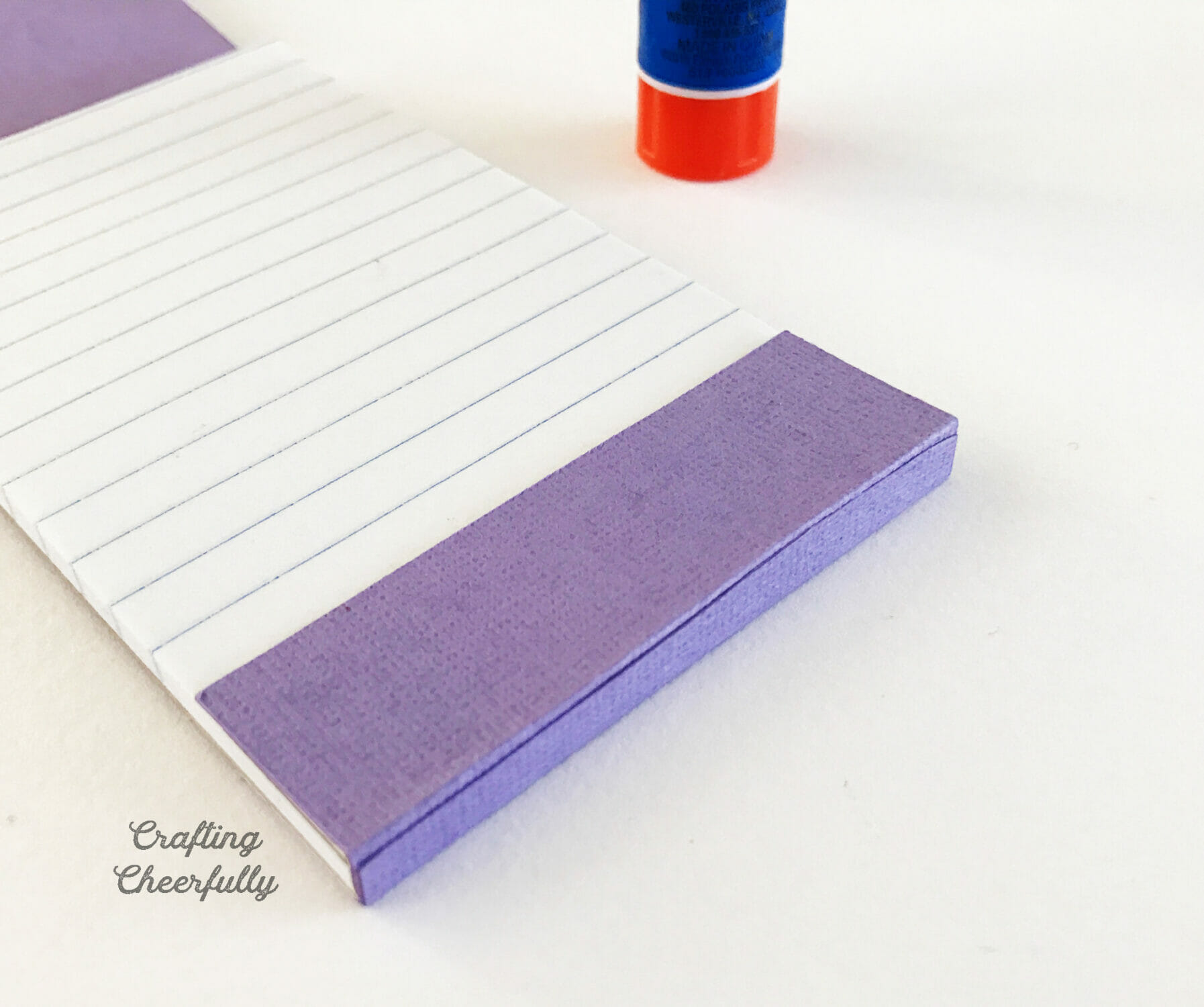 The top of the notepad is wrapped in purple paper.