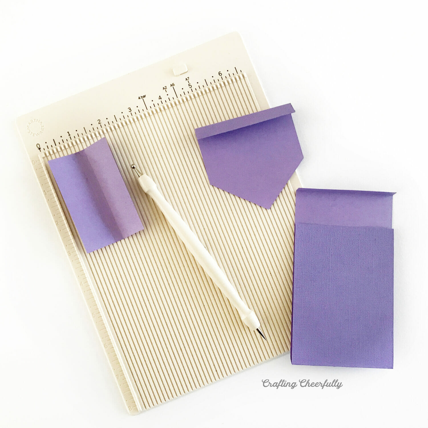 Purple paper scored using a scoring board and stylus.