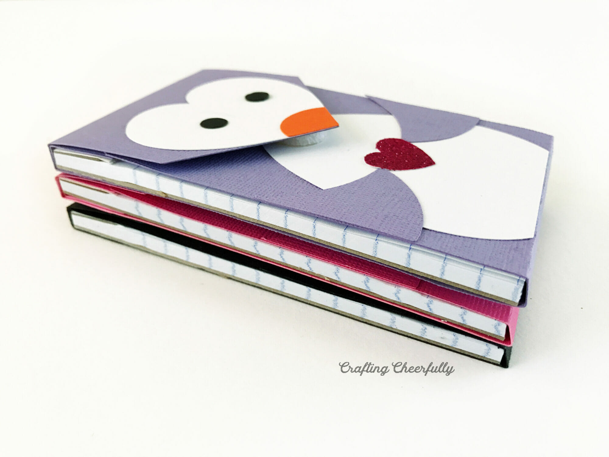Three penguin notepads are stacked on top of each other.