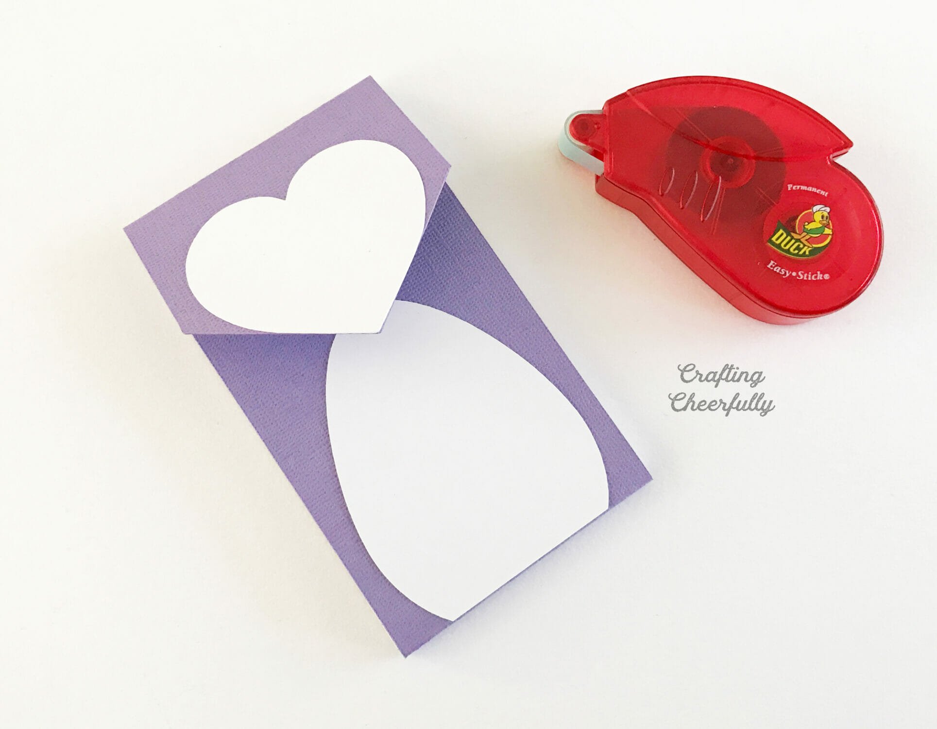 Heart-shaped paper heart is added to the notepad for the penguin face and a white oval is added for the belly.