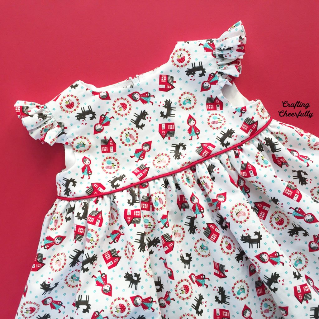 Close up of Little Red Riding Hood baby dress with red cape.