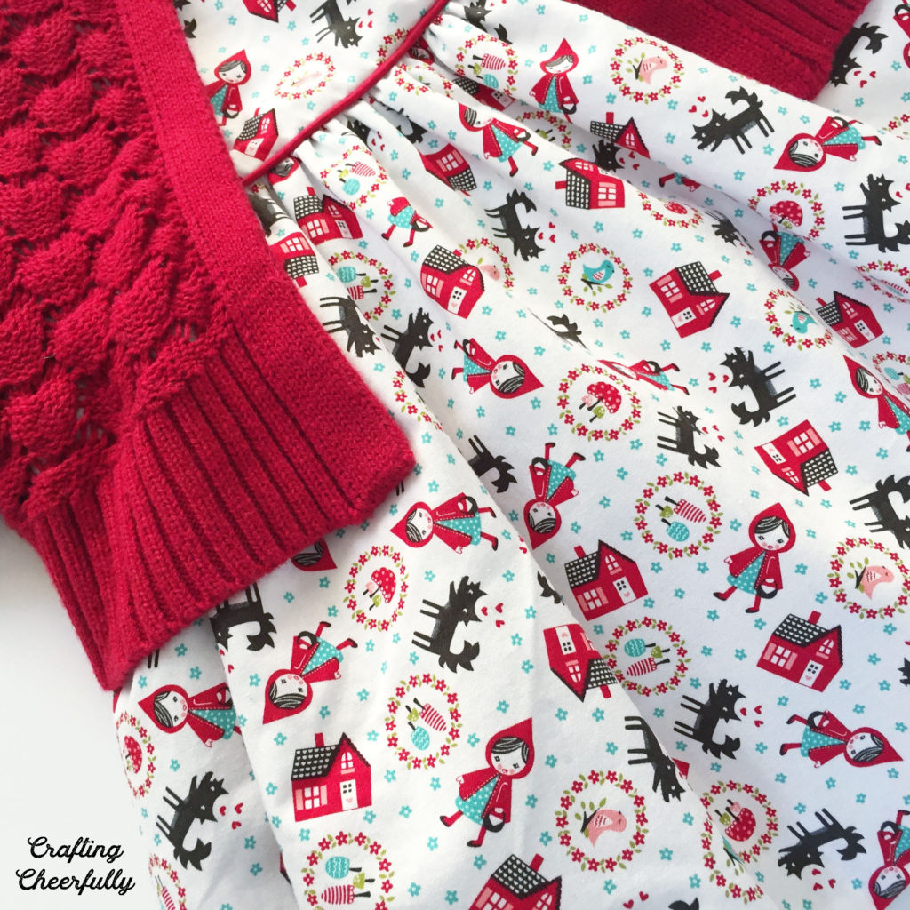 Close up of Little Red Riding Hood baby dress with red cape.