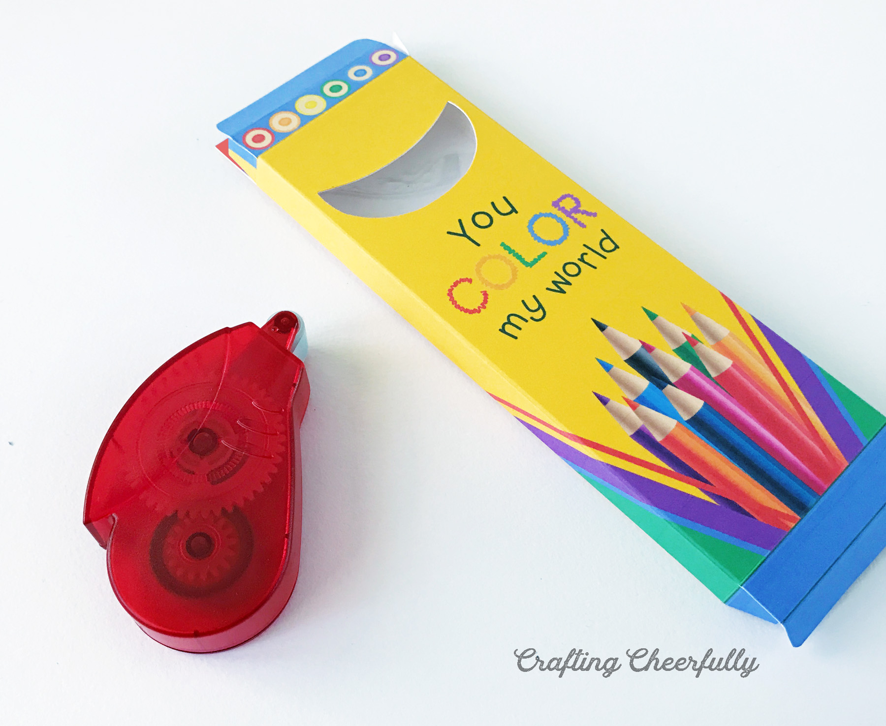 Colored pencil treat box is formed and lays next to a red tape runner.