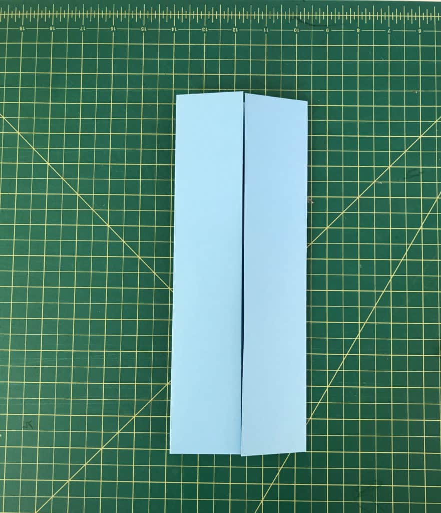 Blue sheet of paper with two ends folded in to meet the center line.