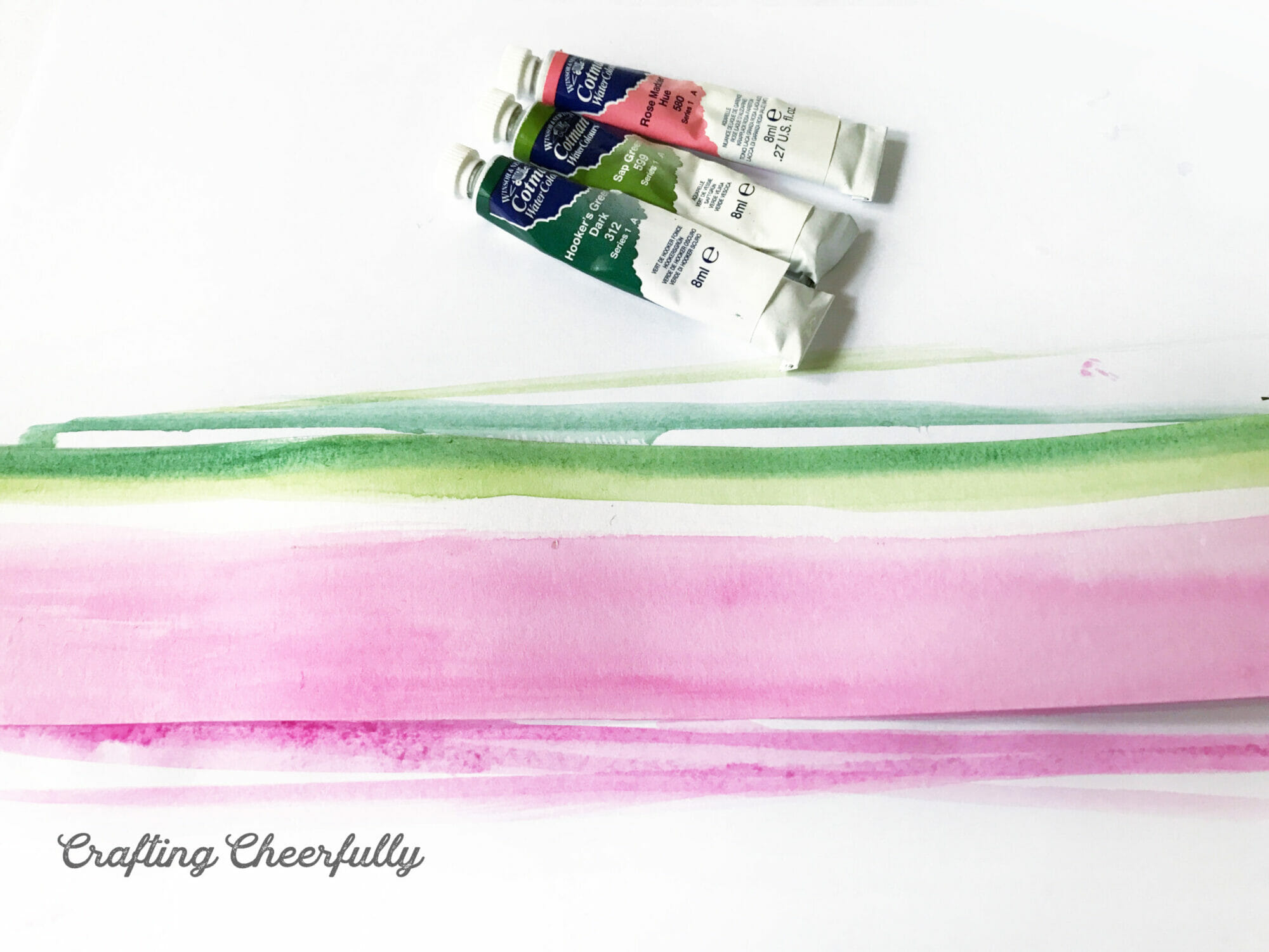 A thin strip of dark green paint is added to the top edge of the paper strip.