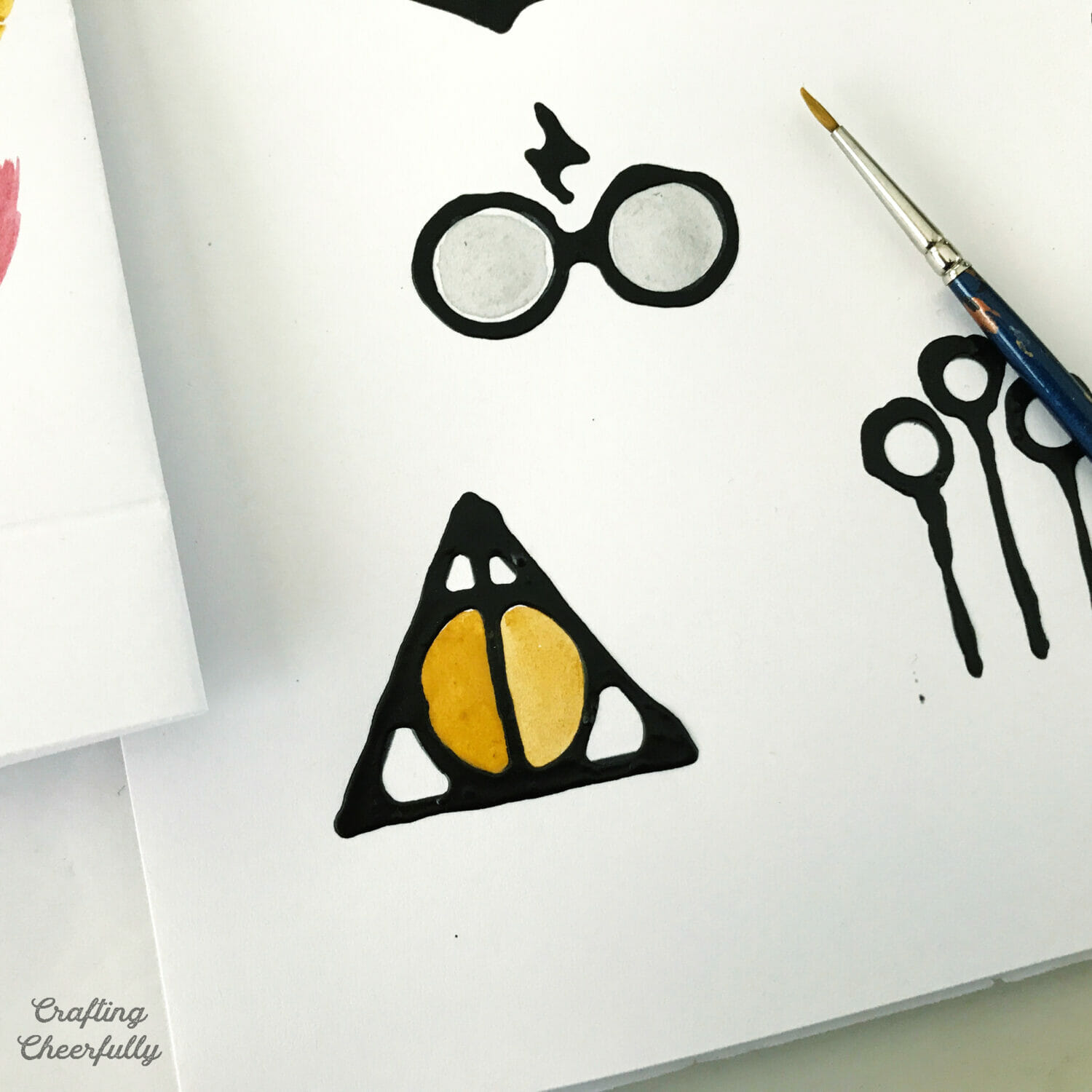 Watercolor paint is added to illustrations outlined in black glue.