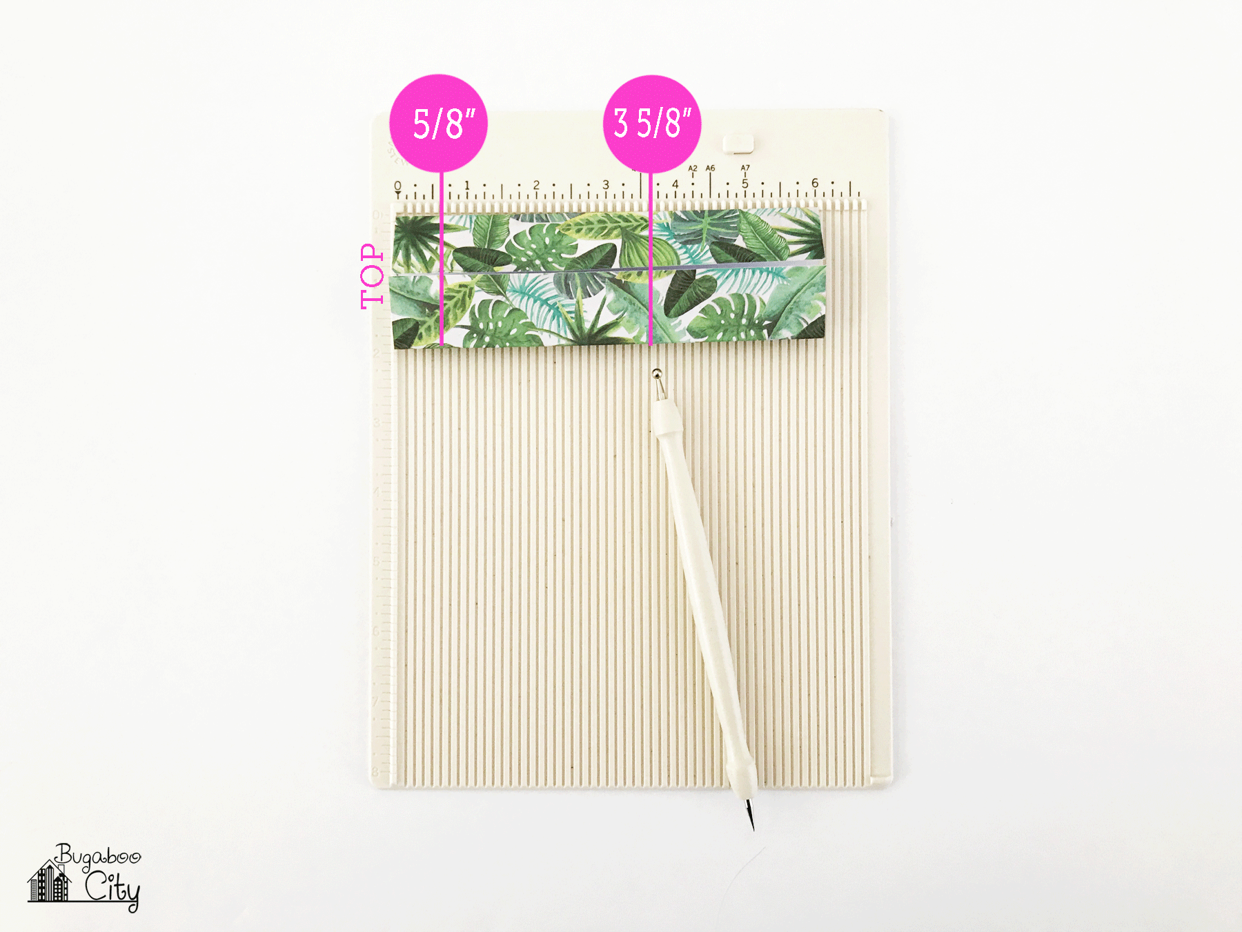 Folded paper lays on a scoring board; picture is marked in pink where to score.