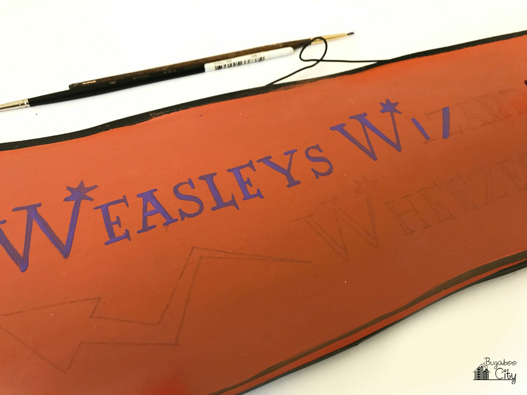 A light pencil outline on an orange wooden sign.