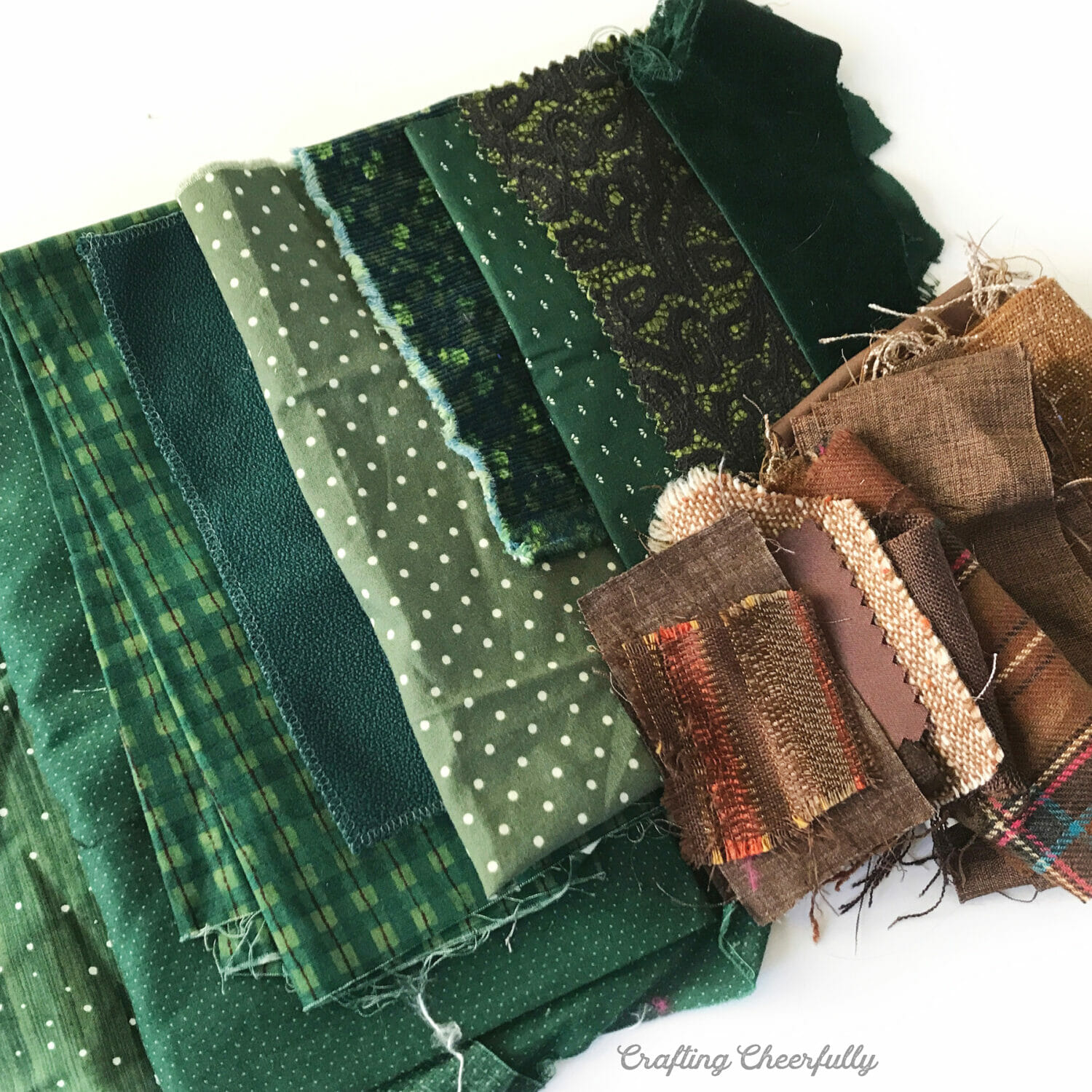 Scraps of green and brown wool used to make the tree banner are arranged on a white table.