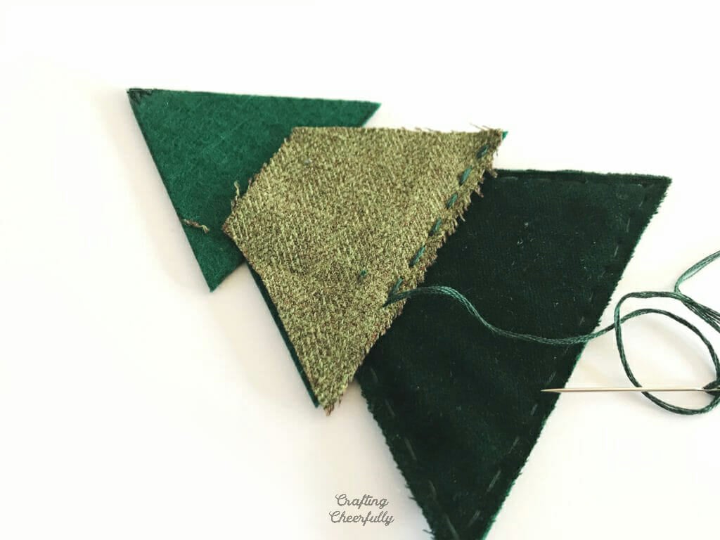 Green felt Christmas tree pennant lays on a white table.