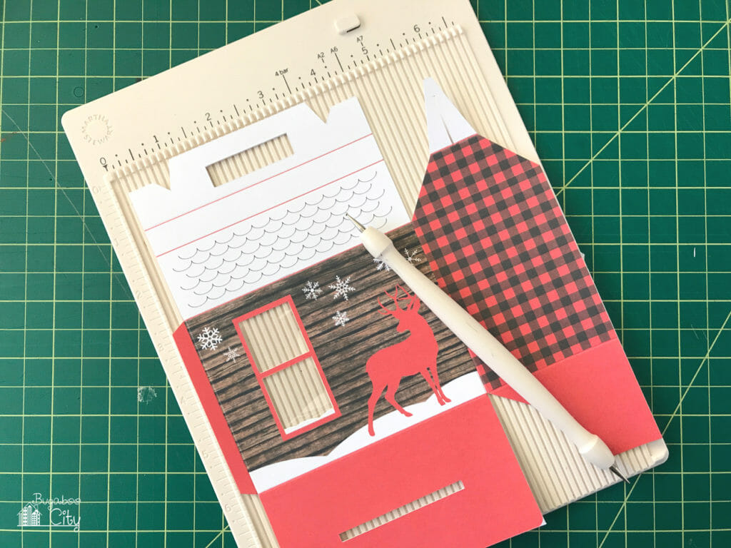 One side of the printable box is scored on a scoring board.