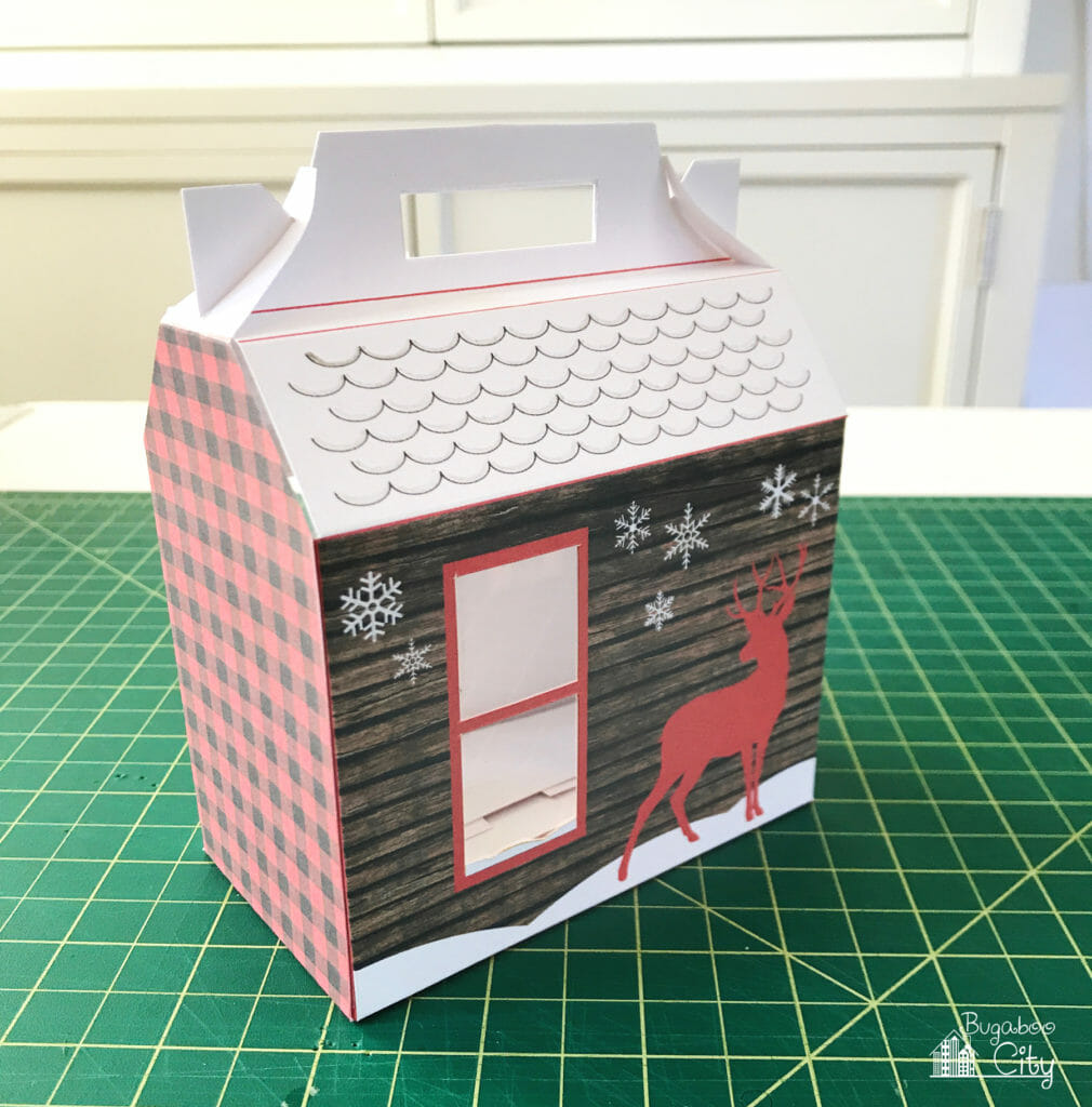 The back of the cozy cabin treat box has a window, snowflakes and a red dear on it. 