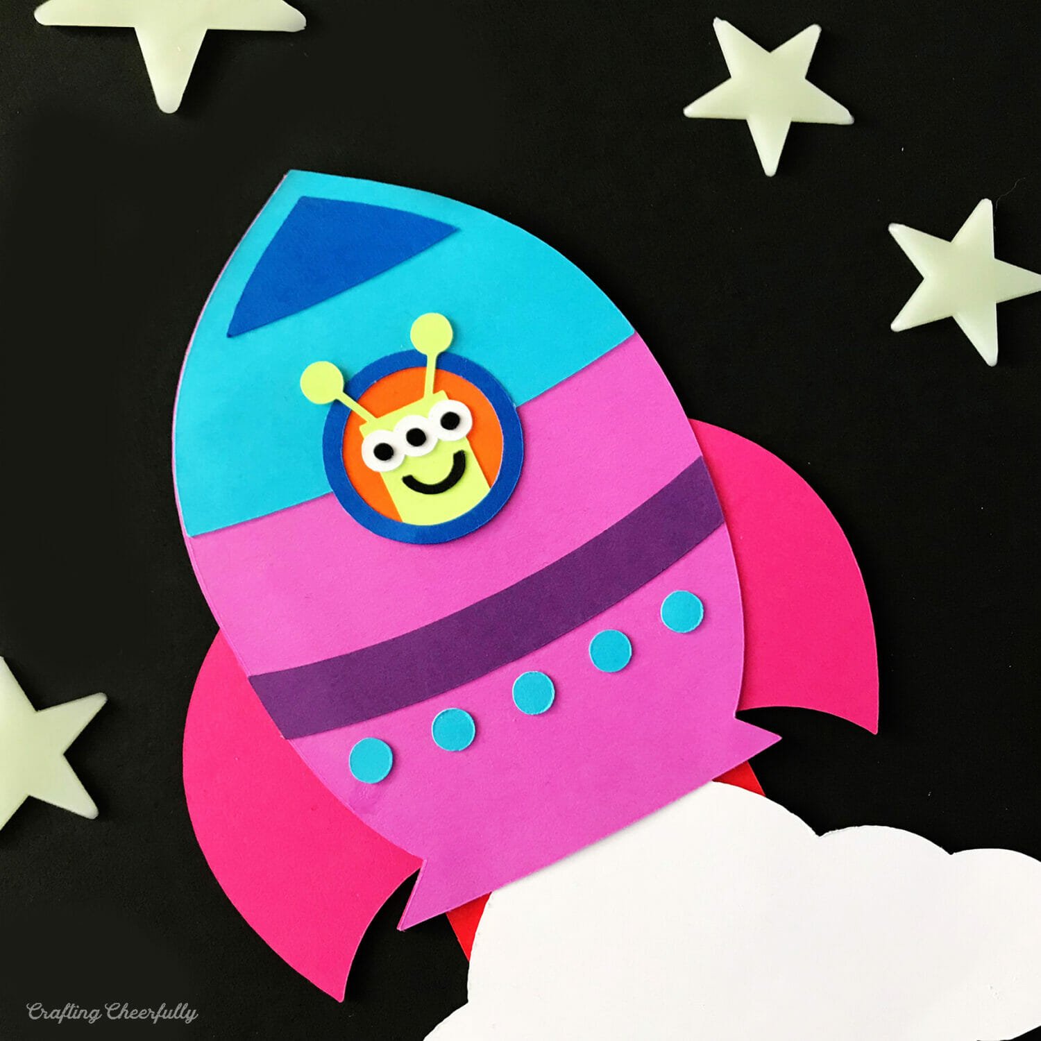 Pink and blue paper spaceship card with a cute green alien in the window.