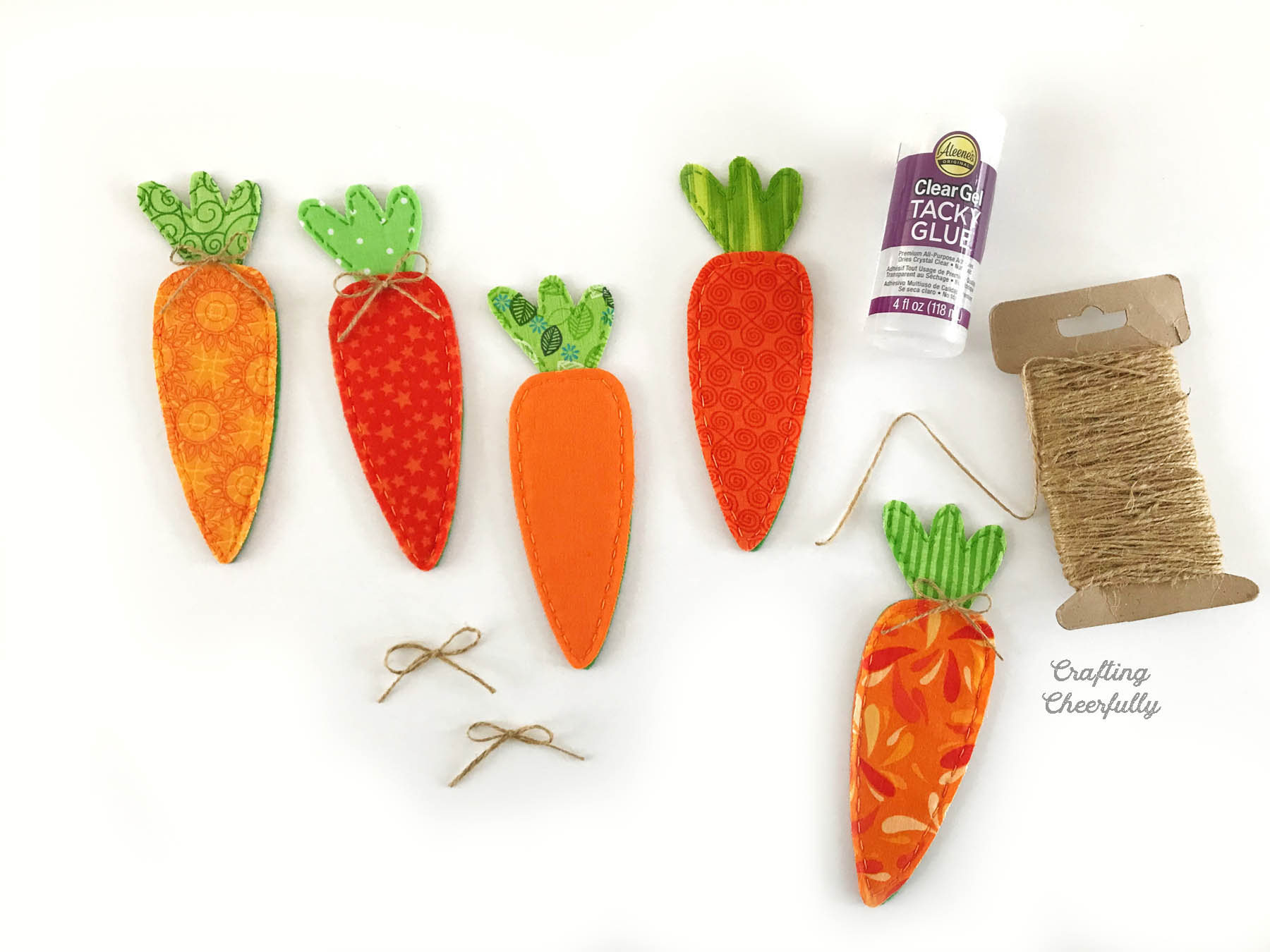Small bows are added to each fabric carrot using twine and fabric glue.